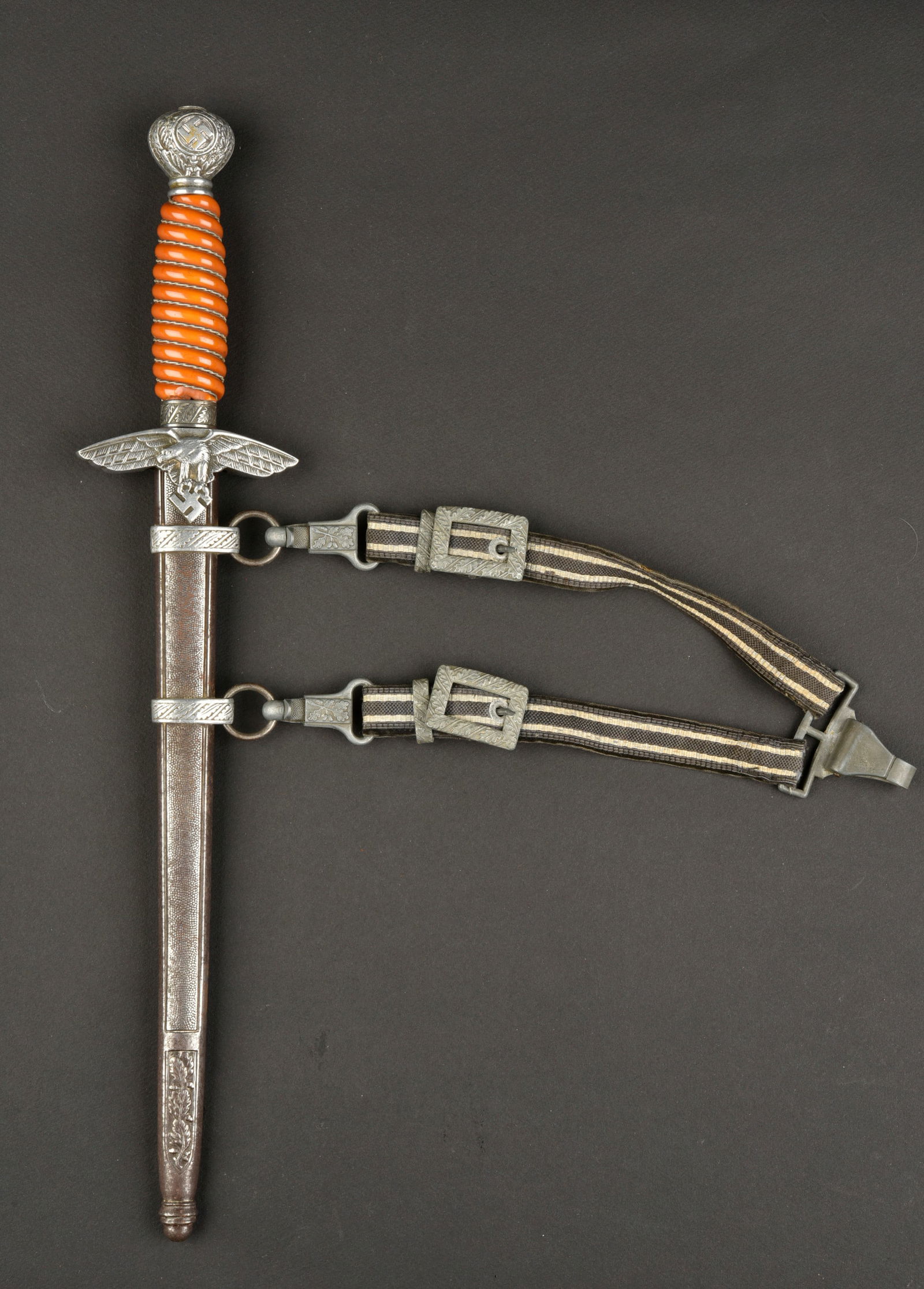 Dague d officier LW. Luftwaffe officer dagger.: Dague d officier de la Luftwaffe. Pommeau en m etal, les insignes nationaux ont perdus leur couleur or. Poign ee de couleur orange, nombreux manques de mati ere aux extr emit es. Filigrane complet. Ga