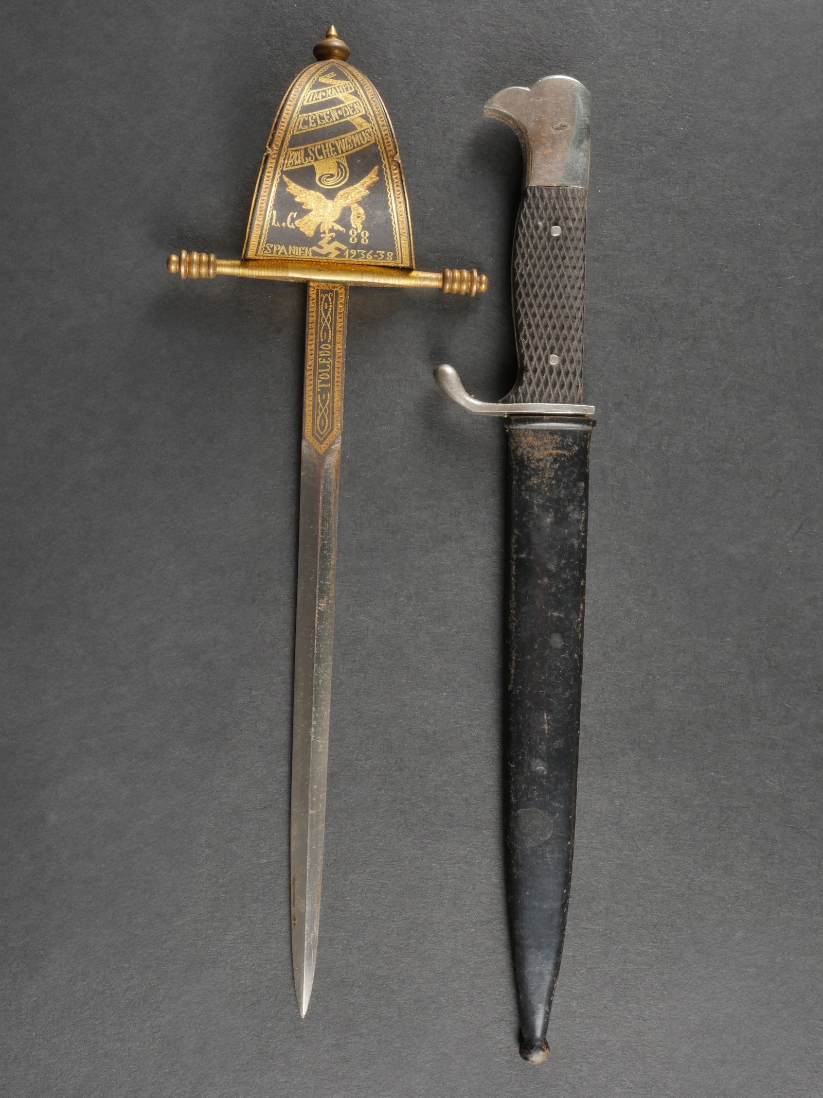 Miniatures de dagues. Miniature daggers.: Miniatures de dague. Comprenant un coupe papier repr esentant une ep ee, avec marquages Im Kampf Legen Spanien 1936-1938, Toledo, sans fourreau, longueur totale 24 cm. Une miniature de baionnette alle