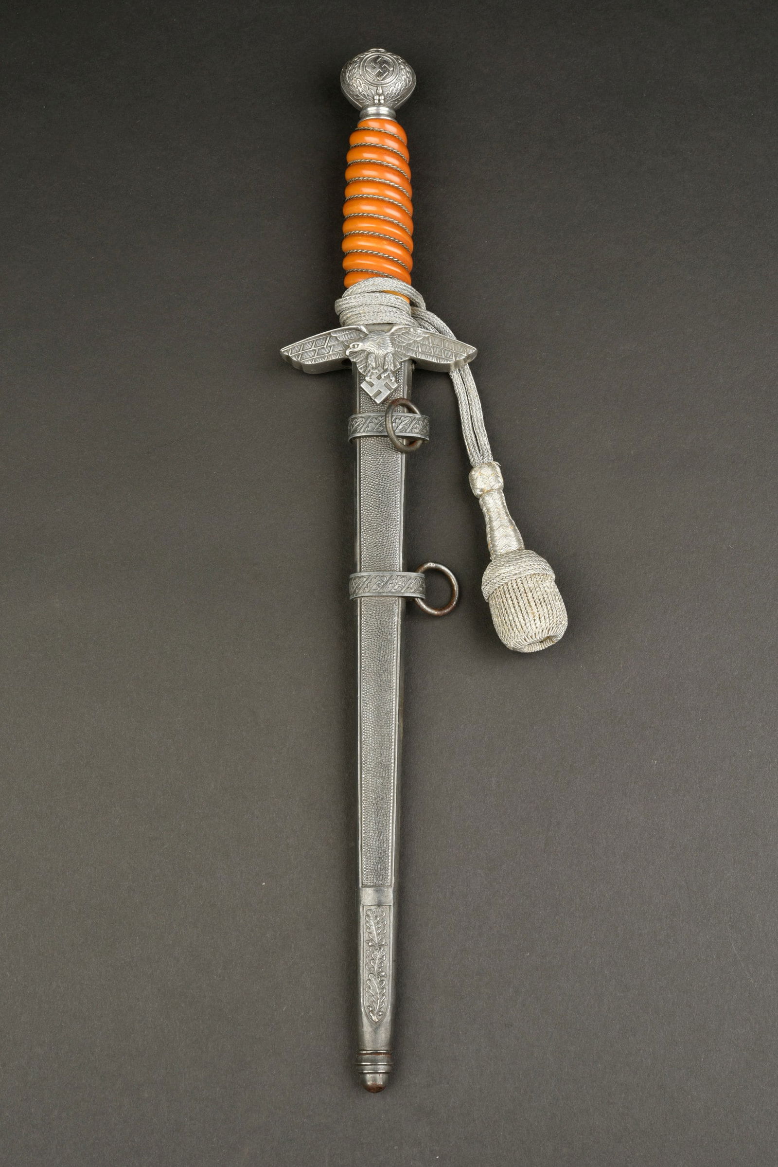 Dague d officier LW. Luftwaffe officer dagger.: Dague d officier de la Luftwaffe. Garnitures en m etal. Les dorures des insignes nationaux sont manquantes. Poign ee en celluloid orange. Filigrane complet. Belle lame partiellement oxyd ee. Fabricati