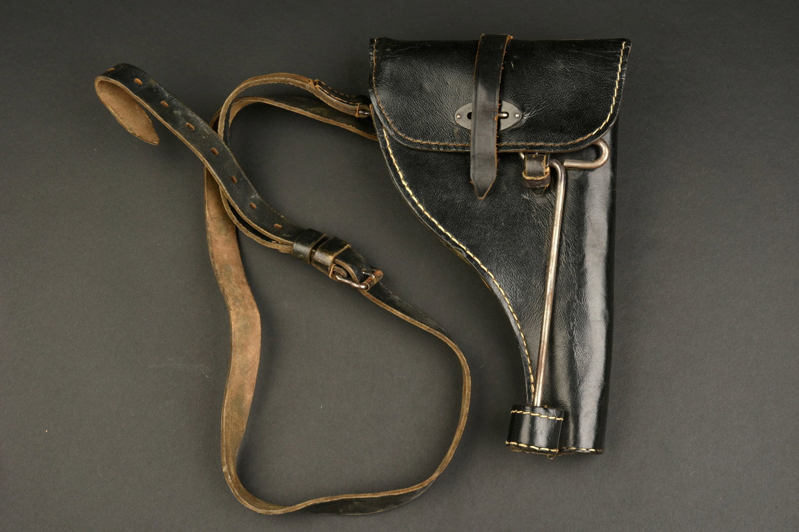 Holster de pistolet lance-fusee. Flare pistol holster.: Holster de pistolet lance-fusee. En epais cuir noir. La sangle de fermeture est presente. Les passants au dos sont presents. La baguette de nettoyage en metal est presente, fabrication GL 43 avec aigl