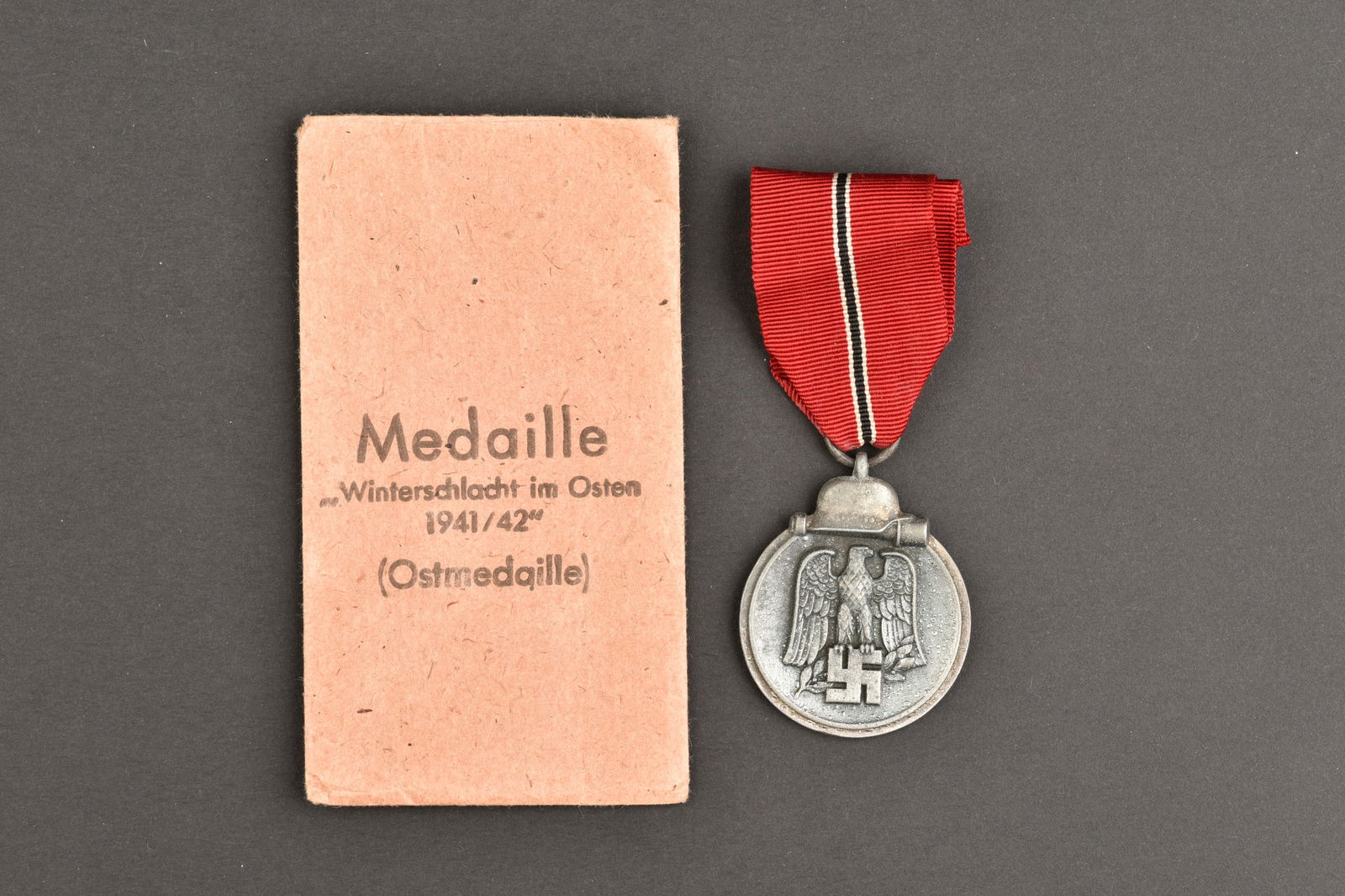 Ostmedaille. Winter medals.: Ostmedaille. En metal, avec ruban. Sachet en papier cartonne, marque Medaille Winterschlacht im Osten 1941/42 Ostmedaille. Fabrication Fritz Zimmermann Stuttgart. A noter une certaine usure et patine