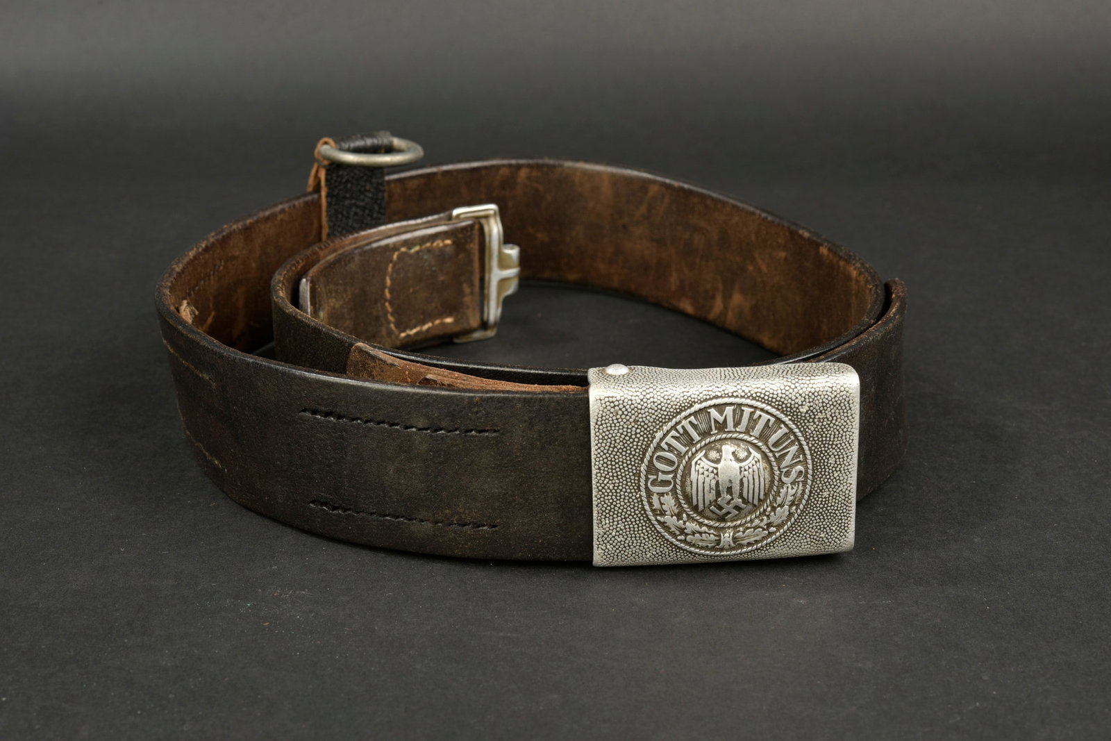 Ceinturon de la Heer. German Heer belt.: Ceinturon de la Heer. Ceinturon en cuir noir. Bouclerie en metal. Taille 95. Marquages presents mais illisibles. Un passant en cuir present avec son anneau metallique. Patte de reglage complete. Boucl