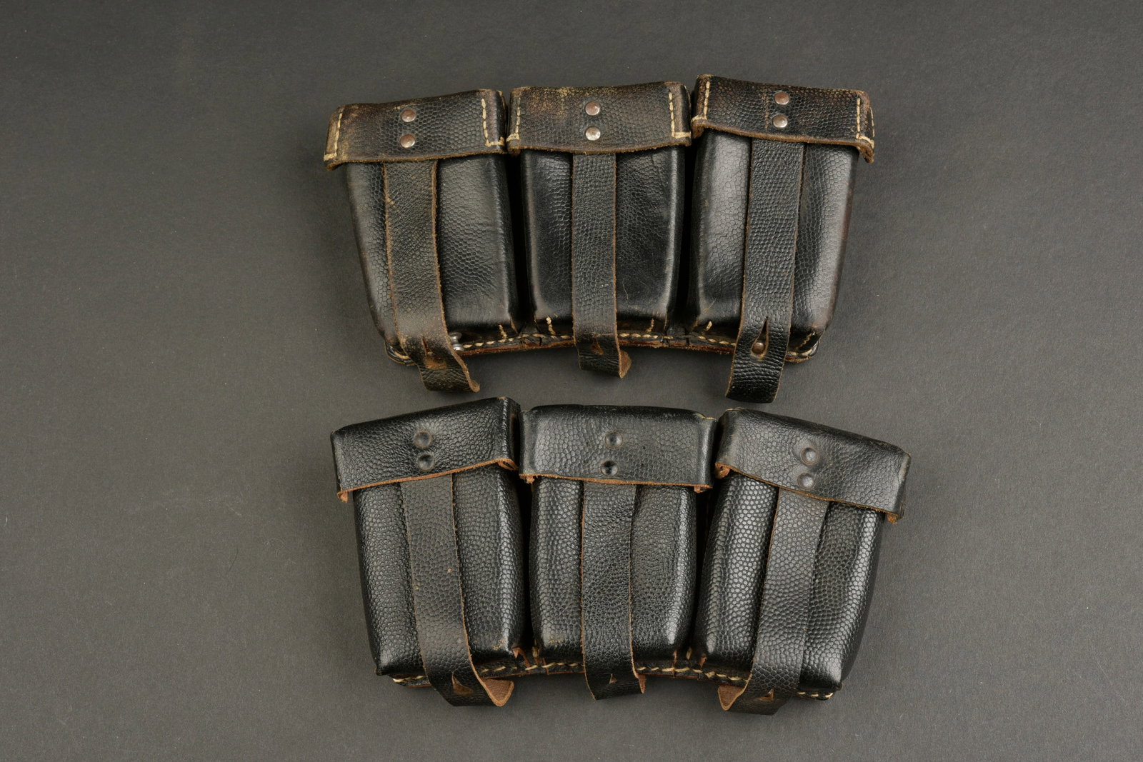 Cartouchieres 98K. Mauser 98K pouches.: Cartouchieres de Mauser 98K. Paire non homogene en cuir grenele noir. Toutes les sangles sont presentes, ainsi que les passants au dos et les anneaux en metal. Marquages RBNr illisibles. A noter une l