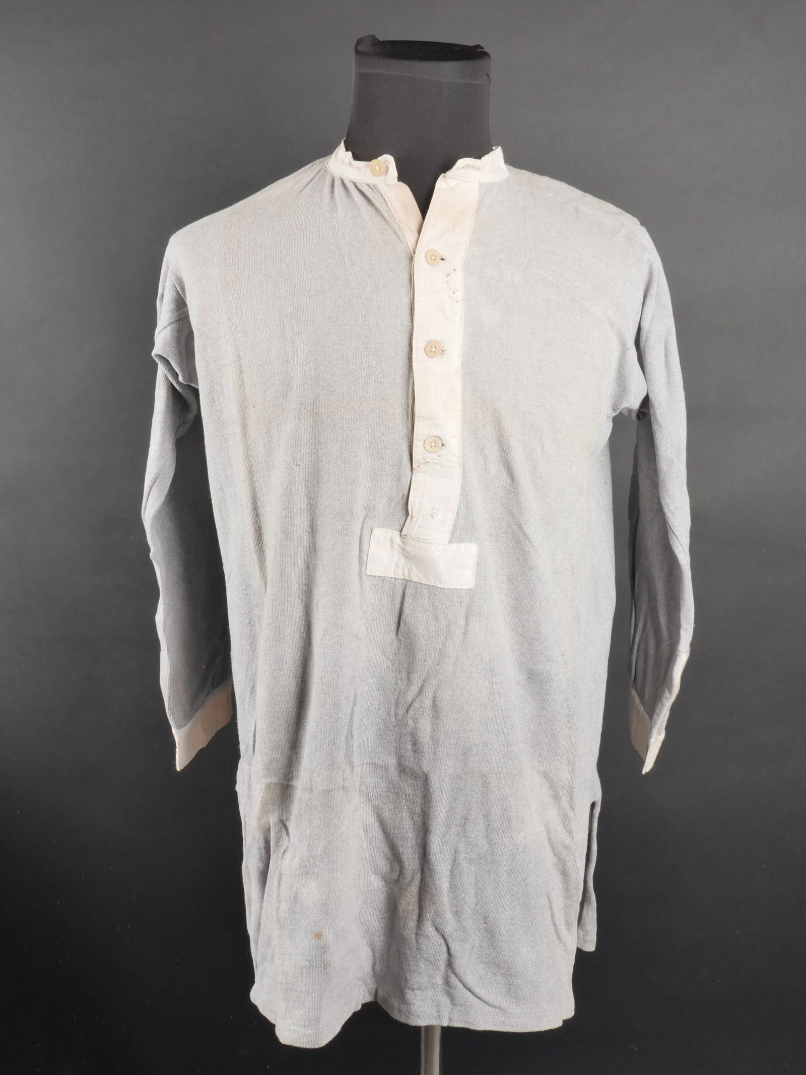 Sous vetement allemand. German underwear.: Sous vetement allemand. Tee-shirt a manches longues. En tissu coton gris et blanc. Tous les boutons sont presents. Indication d une taille 40 dans le col. A noter une certaine usure et patine de la pi