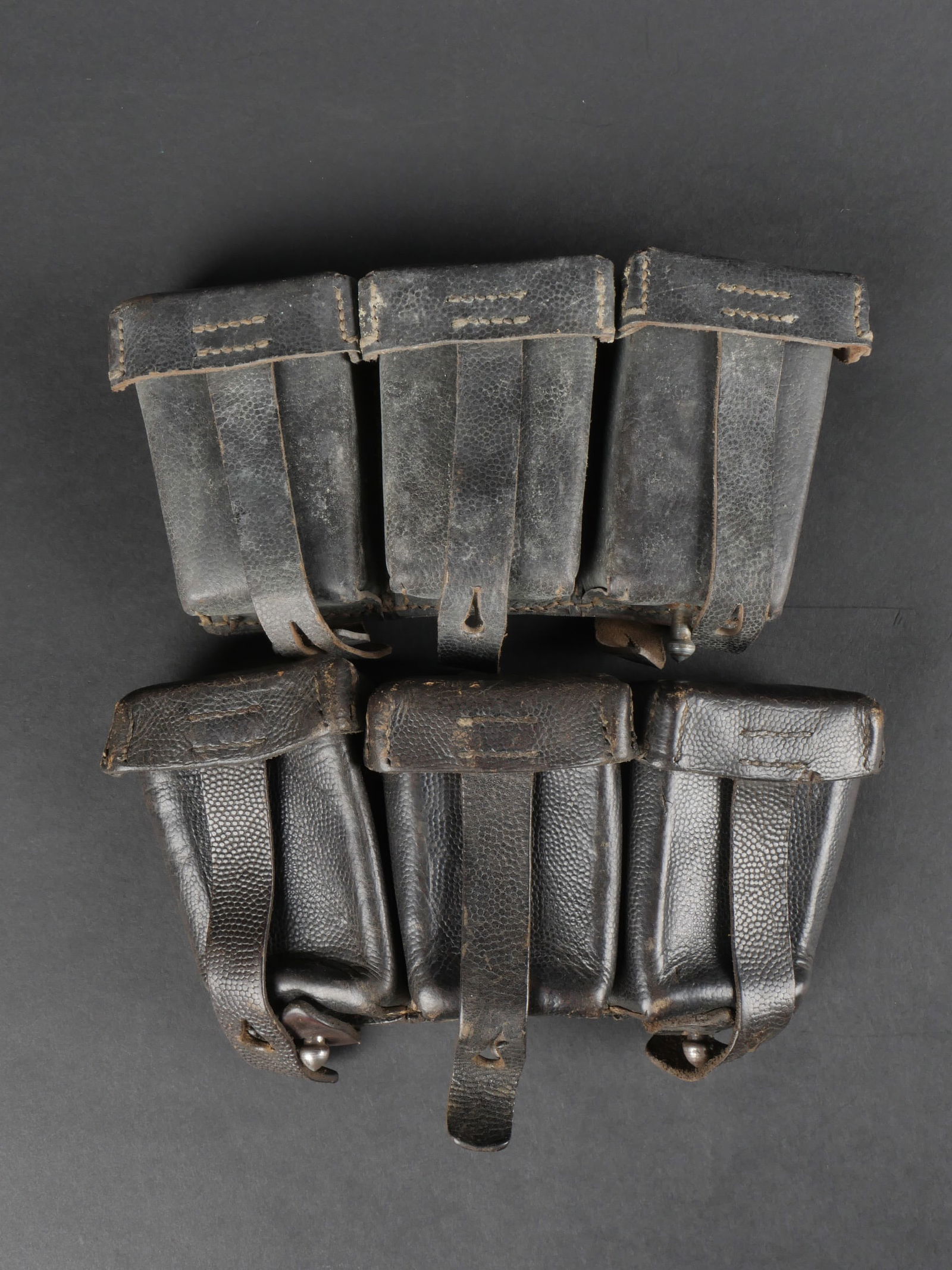 Cartouchieres Mauser 98K. Mauser 98k pouches.: Cartouchieres Mauser 98K. Paire non homogene. En cuir noir grenele. Tous les passants sont presents. Les marques sont illisibles. A noter une certaine usure et patine de la piece. Etat II+. Mauser 98K