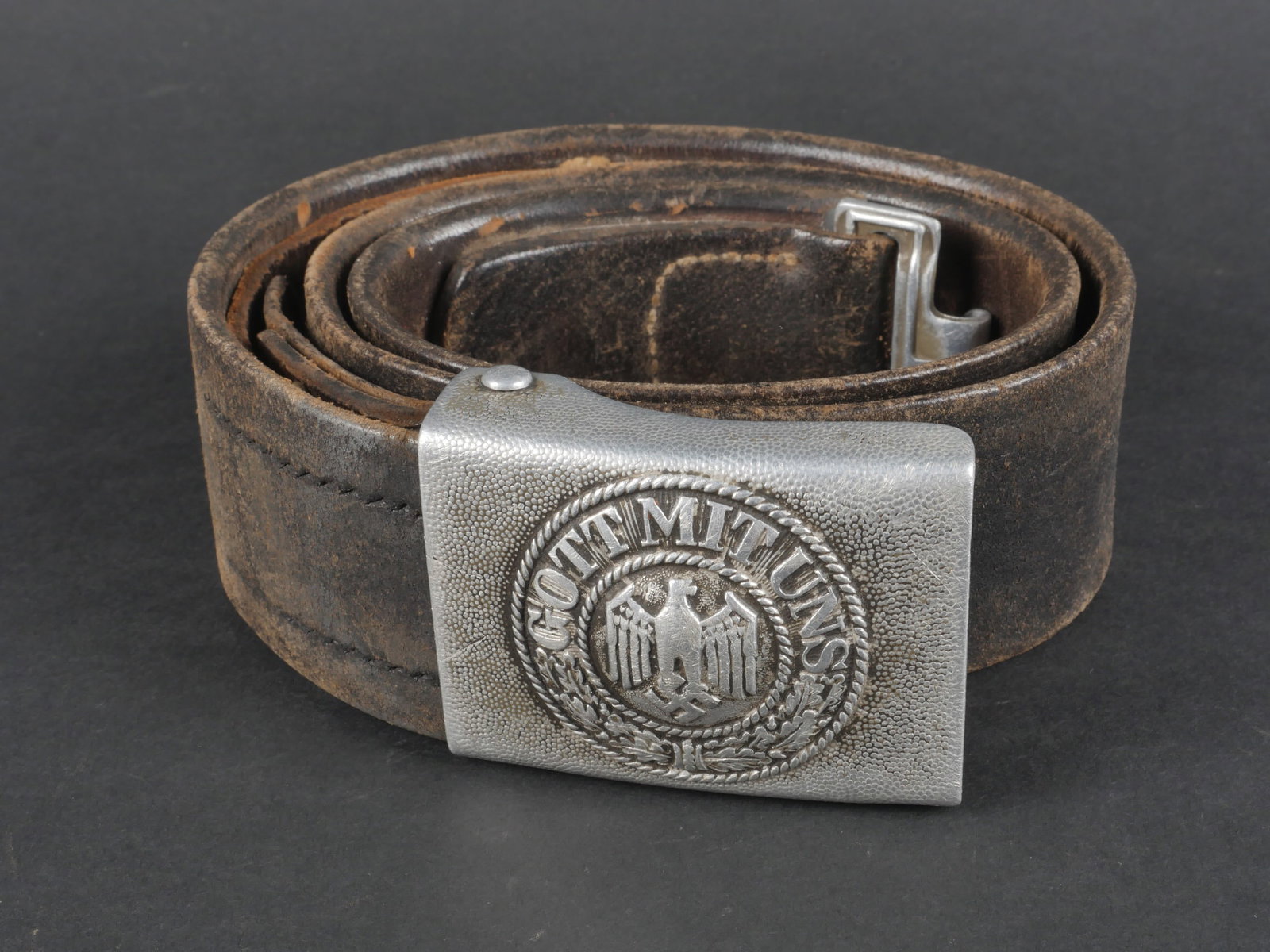Ceinturon allemand. German belt.: Ceinturon de la Heer. Ceinturon en cuir noir, modele avec pattes de reglage. Bouclerie en metal. Probablement retaille. Sans marquages visibles. Toutes les coutures sont refaites. Boucle de ceinturon 