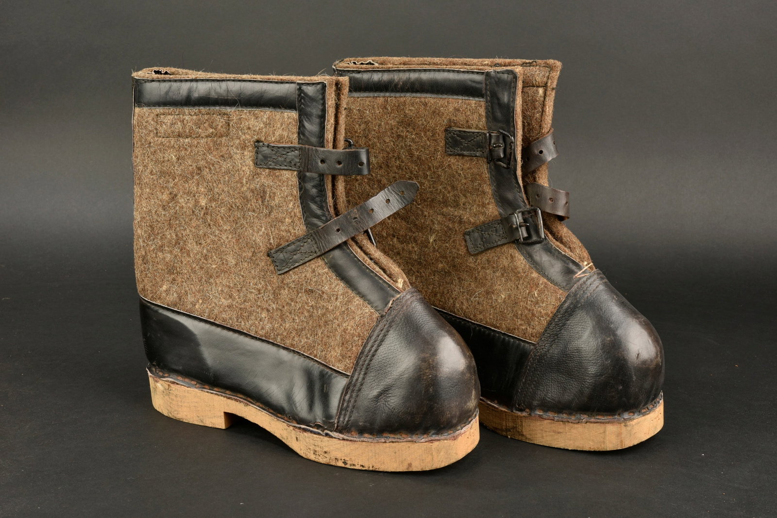 Bottes de garde. German boots.: Bottes de garde. Paire homogene en epaisse feutrine marron et cuir noir. Deux brides de fermeture. Semelles en bois. Etiquettes illisibles. Datee 43. Taille 29. A noter une legere usure et patine de l