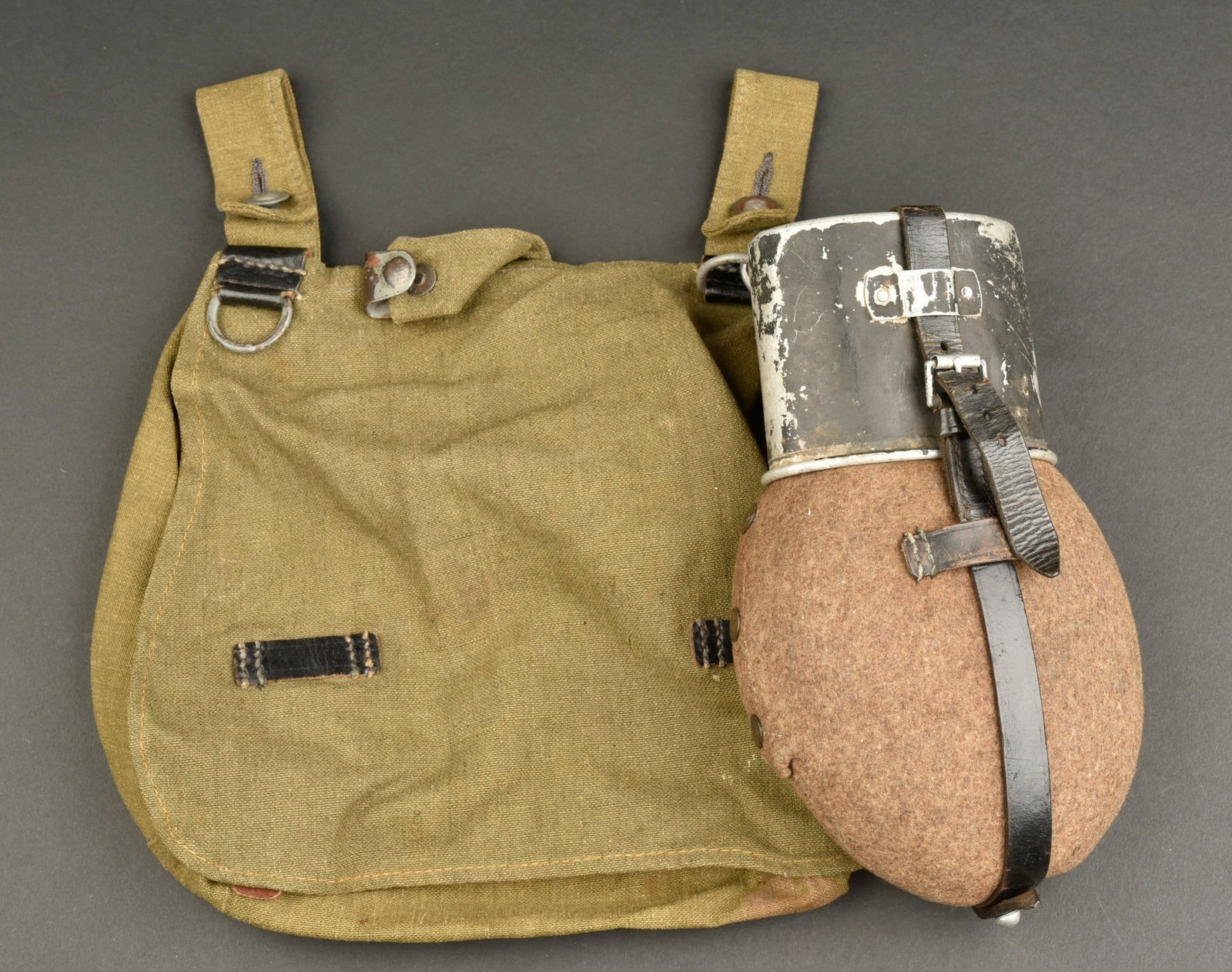 Sac a pain et gourde. German Bread bag and water bottle.: Sac a pain et gourde allemand. Comprenant un sac a pain en forte toile Feldgrau et cuir noir. Toutes les sangles sont presentes. Deux accrocs au dos de la piece. Sans marquages visibles. Une gourde en