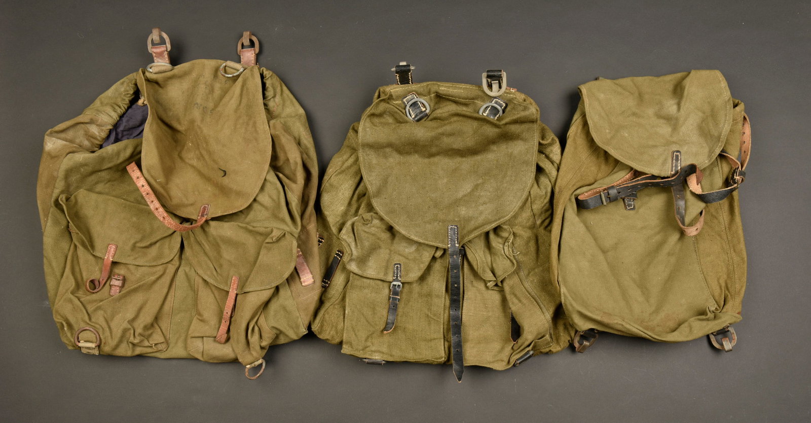 Sac a dos allemand. German rucksack.: Sacs a dos allemand. Comprenant un sac a dos en forte toile Feldgrau et cuir marron, les sangles en cuir sont presentes, les bretelles sont manquantes. Interieur double en tissu bleu. Marquages illisi