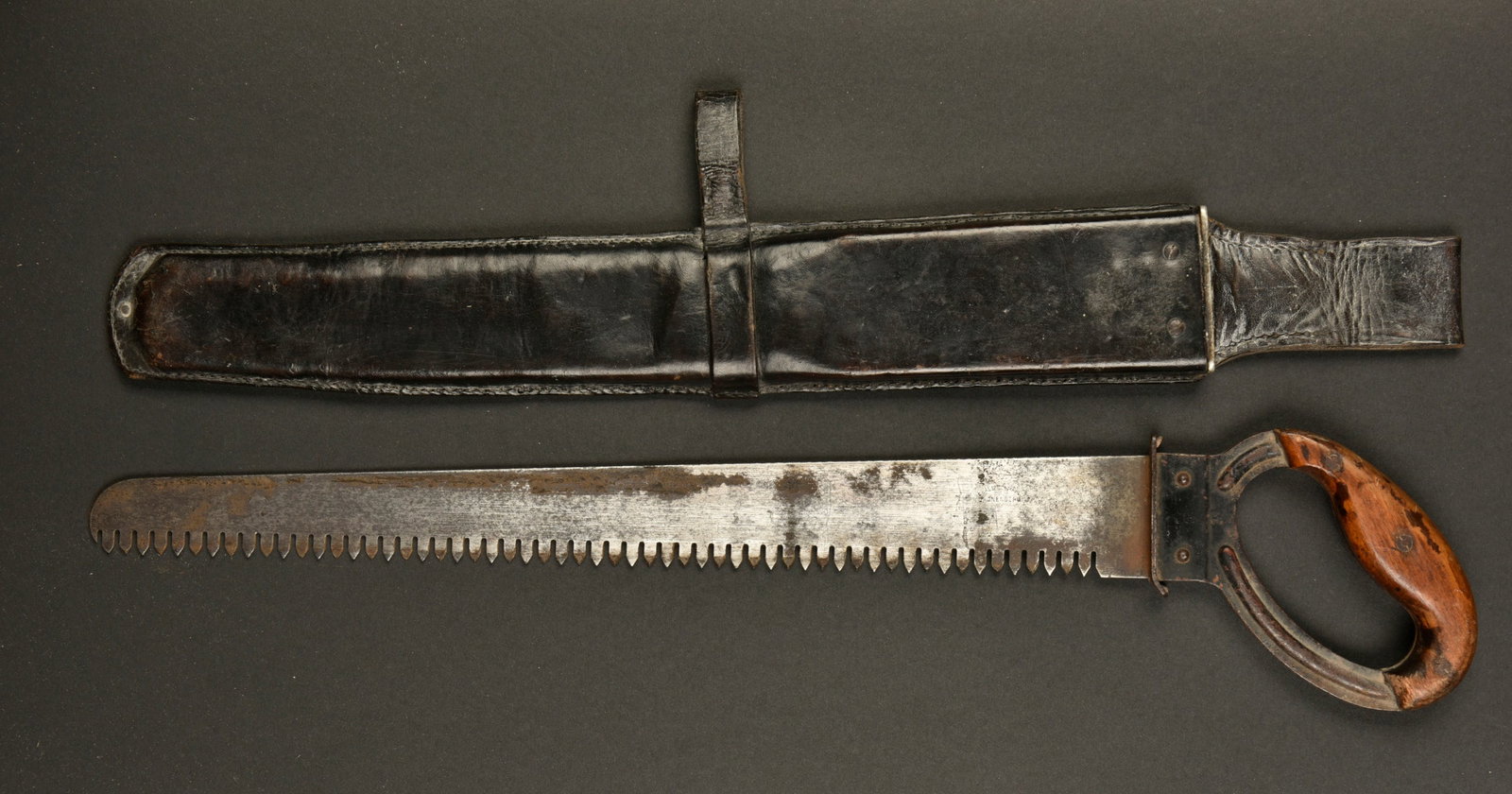 Scie de pionnier. German Pioneer saw.: Scie de pionnier. Scie en metal. Poigne en metal, dans sa couleur d origine a 60%. Plaquettes en bois maintenues par trois vis. Lame partiellement oxydee. Fabrication Ewald Sronenberg, avec aigle Waa.
