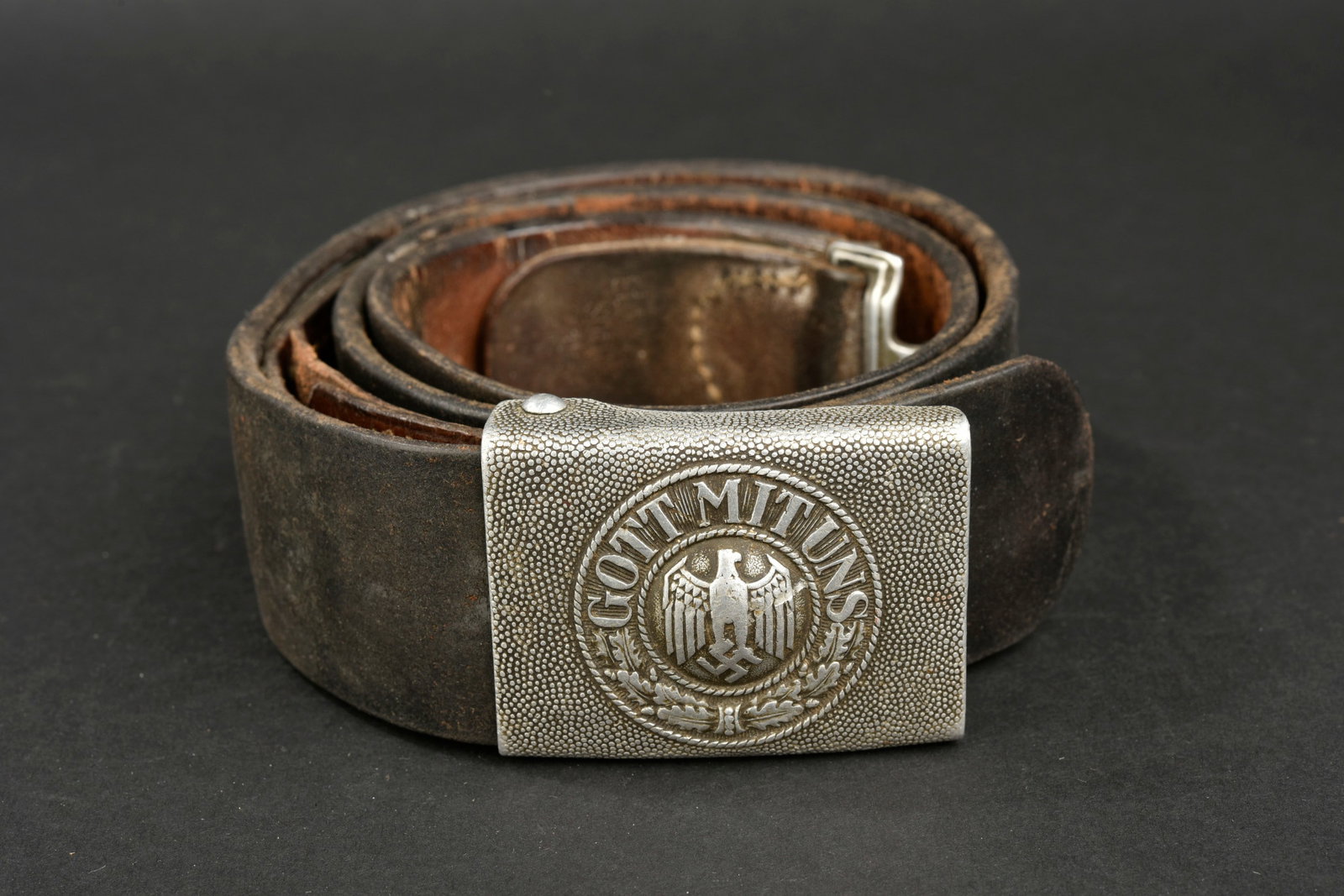 Ceinturon de la Heer. German belt.: Ceinturon de la Heer. Ceinturon en cuir noir, bouclerie en metal marquee OLC. Patte de reglage presente, taille 100, les marquages sont illisibles. Boucle de ceinturon en aluminium grenele, sans marqu