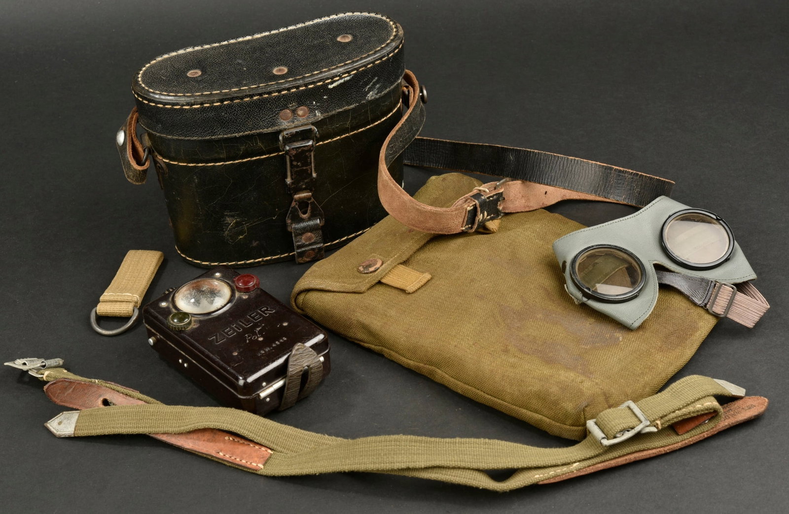Equipement allemand. German equipment.: Equipement allemand. Comprenant un boitier pour jumelle en epais cuir noir, vide, la couture arriere et le fermoir sont manquants. La sangle de transport est presente. Fabrication CXN. Une paire de lu