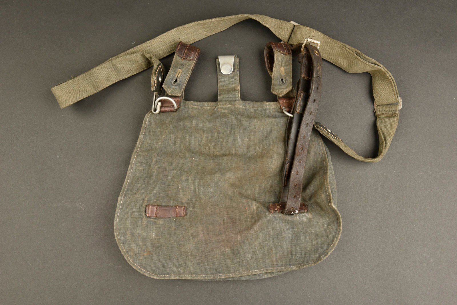 Sac a pain LW. Luftwaffe bread bag.: Sac a pain de la Luftwaffe. En toile gris bleu et cuir marron. Une sangle en cuir est presente. Marquages illisibles sous le rabat et LBAS 38. Sangle de transport en toile gris/bleu, les mousquetons s
