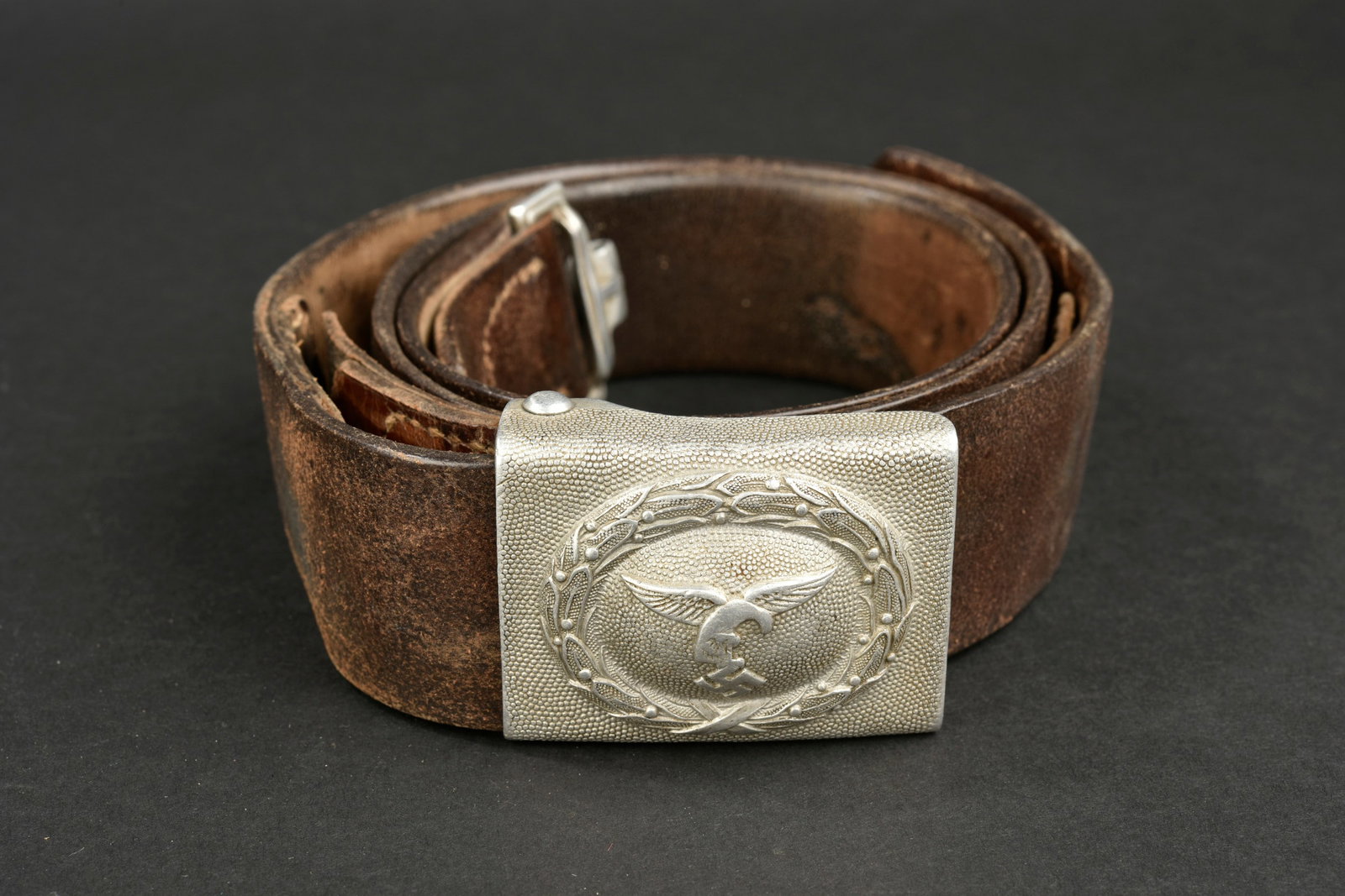 Ceinturon LW. Luftwaffe belt.: Ceinturon troupe de la Luftwaffe. En cuir noir use, bouclerie en metal, taille 100, deux perforations au bout du ceinturon, marquages regimentaires 4/Lg.nachr Rgt 11. Boucle de ceinturon en aluminium 