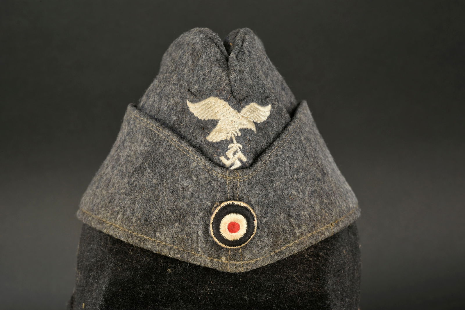 Calot LW. Luftwaffe cap.: Calot de la Luftwaffe. En drap gris/bleu, aigle et cocarde brodees. Interieur double en tissu soyeux gris/bleu, marquages RBNr 0/0390/0193, taille 58. A noter une certaine usure et patine de la piece,