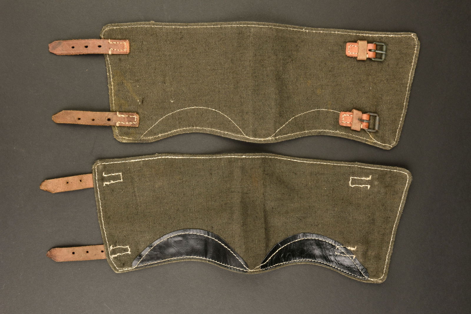 Guetre LW. Luftwaffe gaiters.: Guetres de la Luftwaffe. En tissu gris bleu et cuir fauve. Paire homogene en cuir noir. Renforts interne en cuir noir. Les marquages sont illisibles. A noter une certaine usure et patine de la piece.