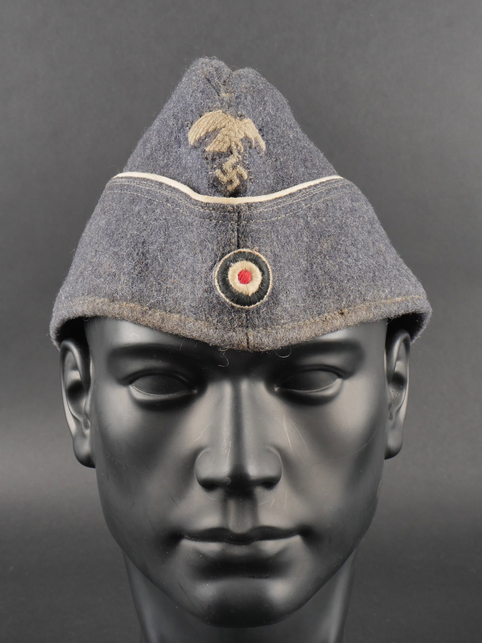 Calot Luftwaffe. Luftwaffe cap.: Calot de la Luftwaffe. En drap gris bleu. Lisere blanc faisant le tour de la coiffure, celui-ci est posterieur. Cocarde et aigle remontes. Interieur double en satinette violette. Marquages Erich Bergm