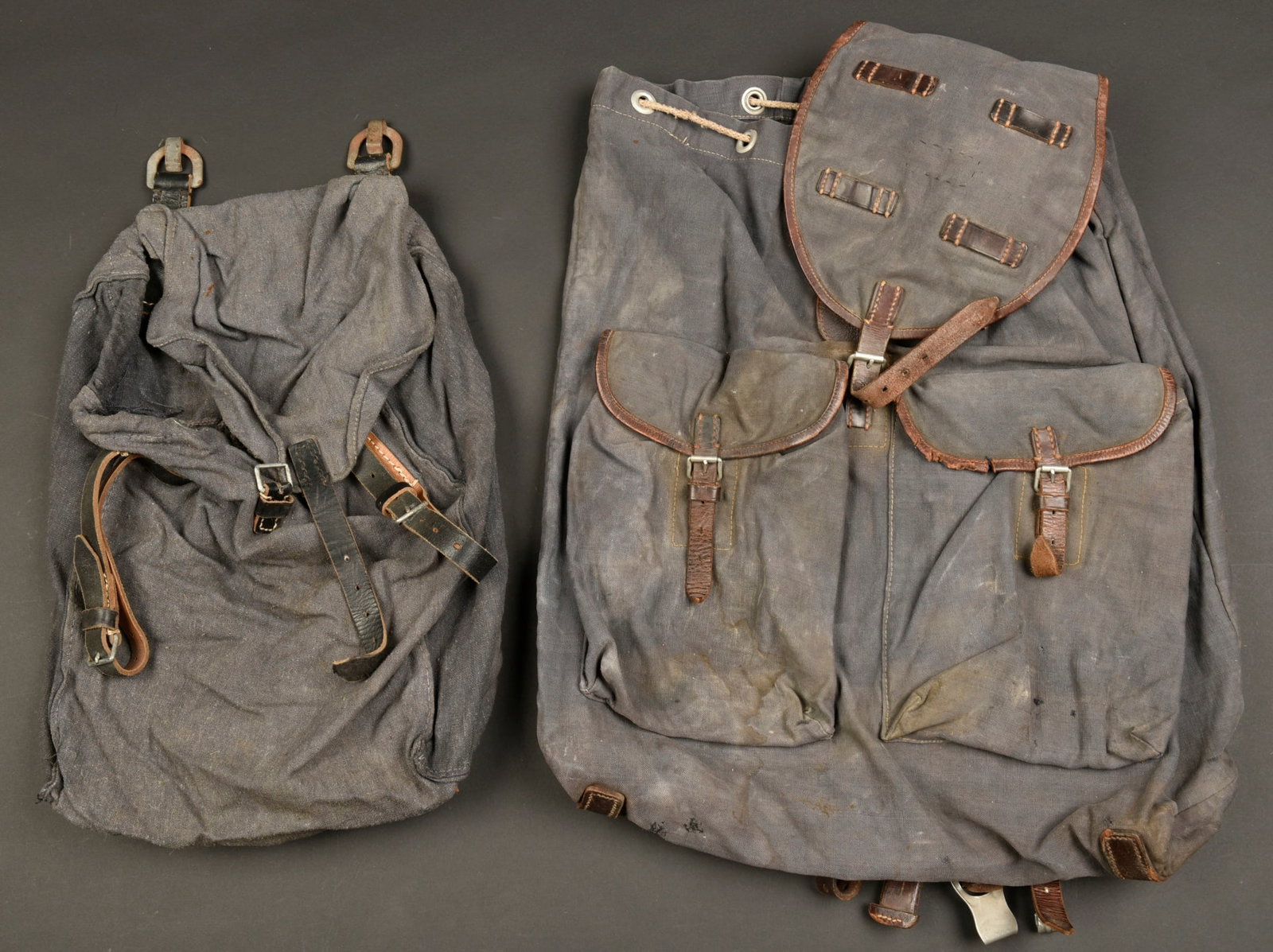 Sacs a dos LW. Luftwaffe backpack.: Sacs a dos de la Luftwaffe. Comprenant un sac a dos en forte toile gris/bleue et cuir marron. Les bretelles en cuir sont presentes. Le cordon de serrage est present. Marquages au dos illisibles, etiqu