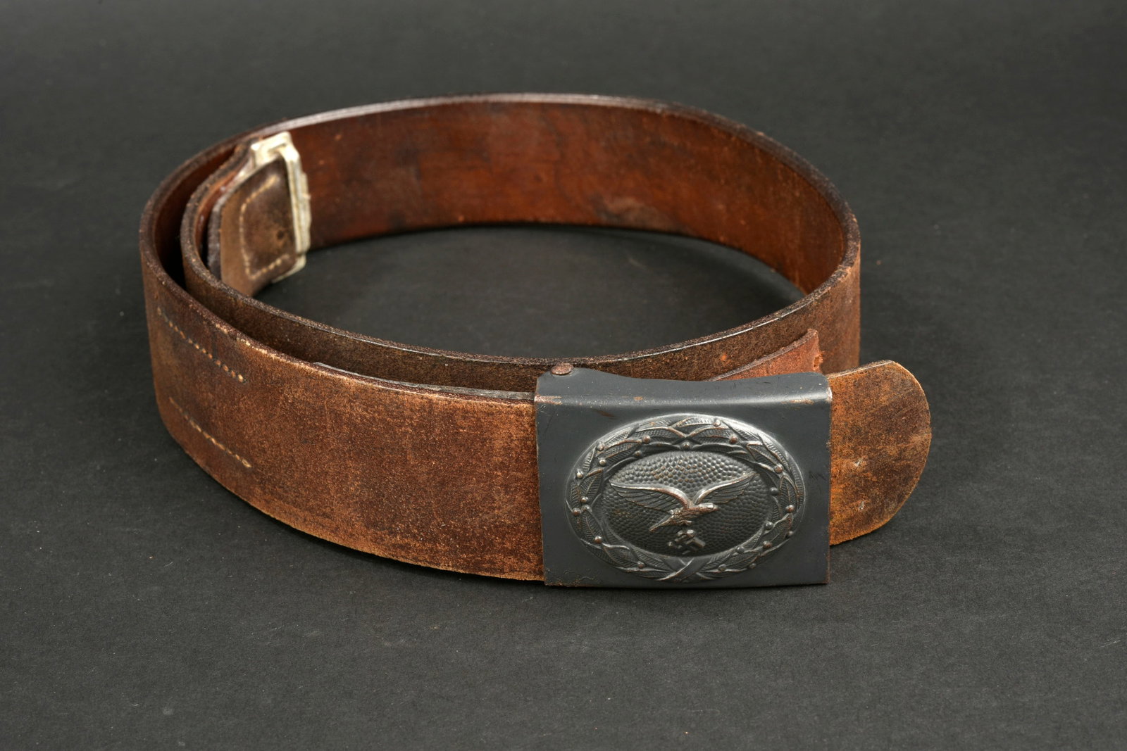 Ceinturon LW. Luftwaffe belt.: Ceinturon de la Luftwaffe. En cuir marron. Bouclerie en aluminium. Les marquages sont illisibles. Patte de reglage complete. Taille 95. Boucle de ceinturon en metal, peinture gris/bleu a 85%. Sans mar
