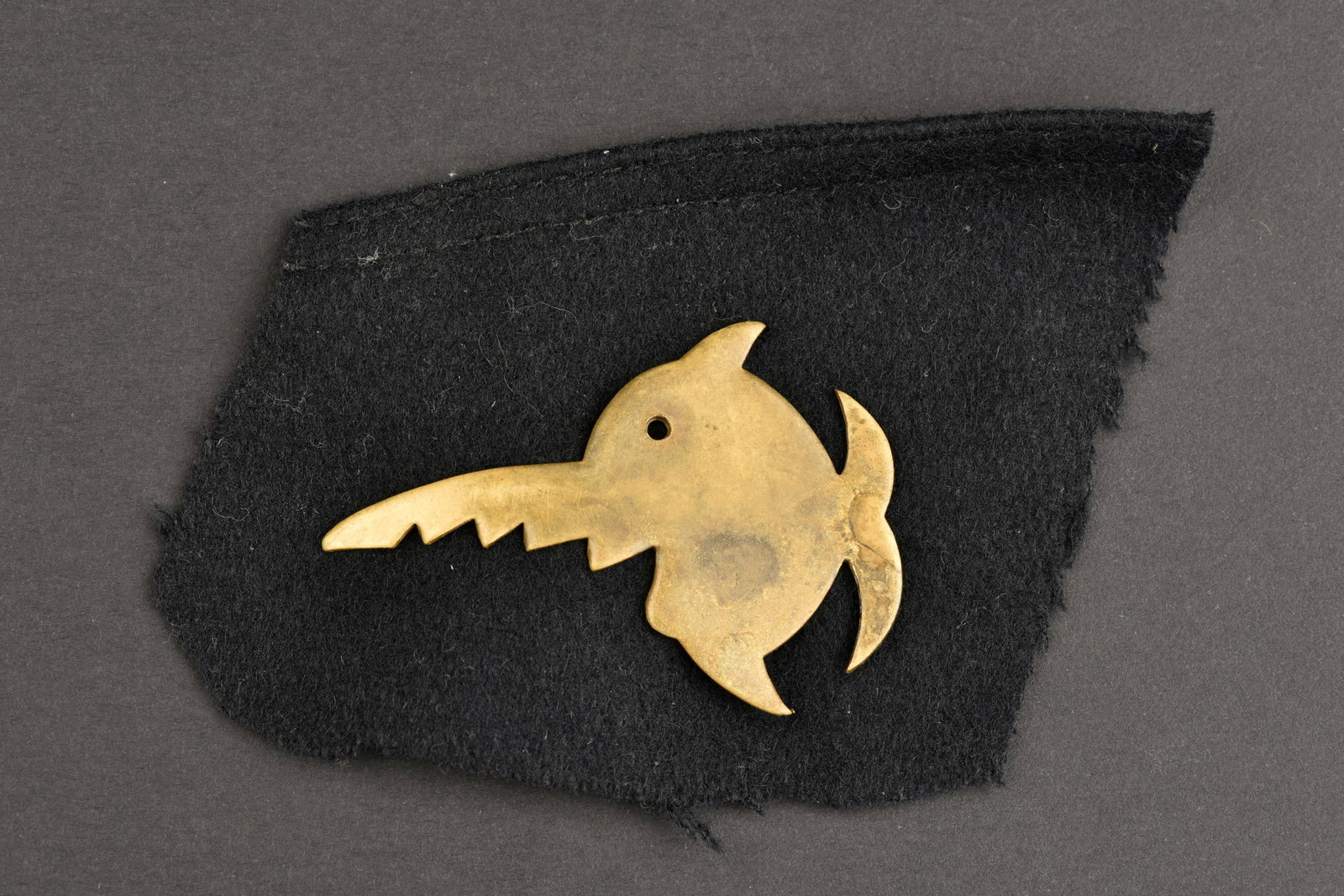 Insigne U Boot. U Boot insignia.: Insigne U Boot. En metal couleur or. Deux pattes de fixationau dos. Insigne de la 9eme U BOOT Flottille. Monte sur un morceau de calot decoupe.a noter une certaine usure et patine de la piece. Etat II