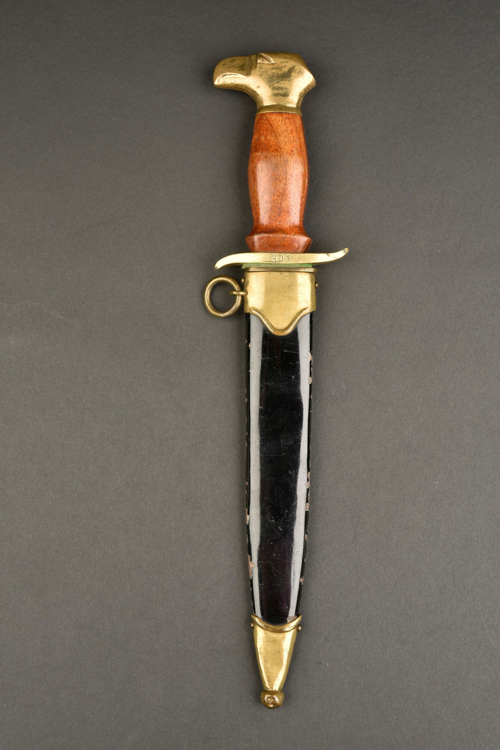 Dague Hlinka. Hlinka dagger.: Dague Hlinka. Pommeau a tete d aigle en metal couleur bronze. La visserie est en parfait etat. Poignee en bois marron, presentant quelques traces d usure et de verni. Garde en S, marquee HDG. Belle la