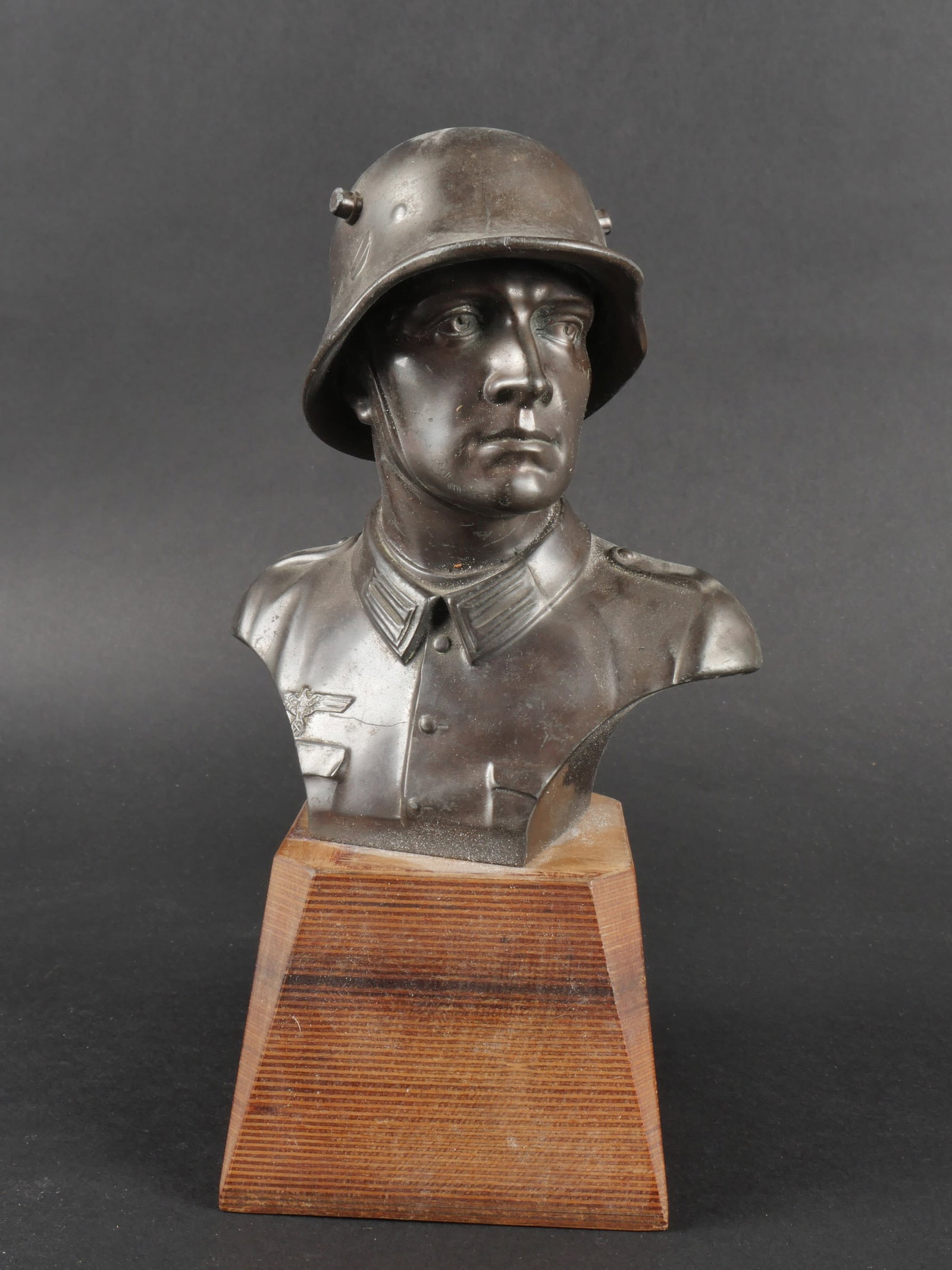 Buste d un soldatallemand. Bust ofa German soldier.: Buste d un soldatallemand. En metal, representant un soldatallemand portant un casque de la premiere guerre mondiale. Socle en bois relativement moderne. Hauteur 24 cm.a noter une certaine usure et pa