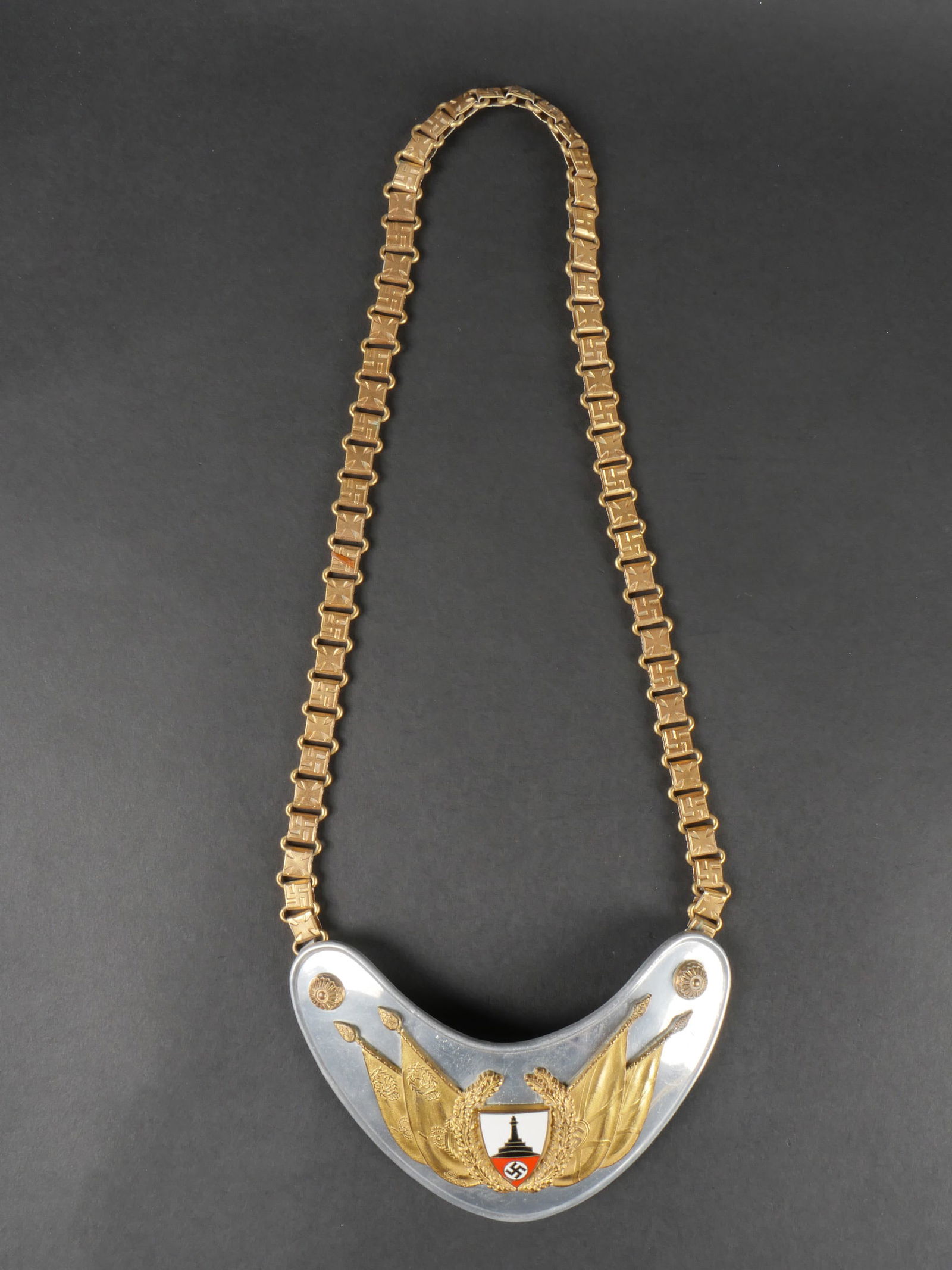 Hausse col du Kyffhauserbund. Kyffhauserbund gorget.: Hausse col du Kyffhauserbund. Enaluminium. Insigne central emaille. Chainette complete,alternant des insignes nationaux et des croix de fer. Dos de la piece double en drap noir, fortement mite. Marqua