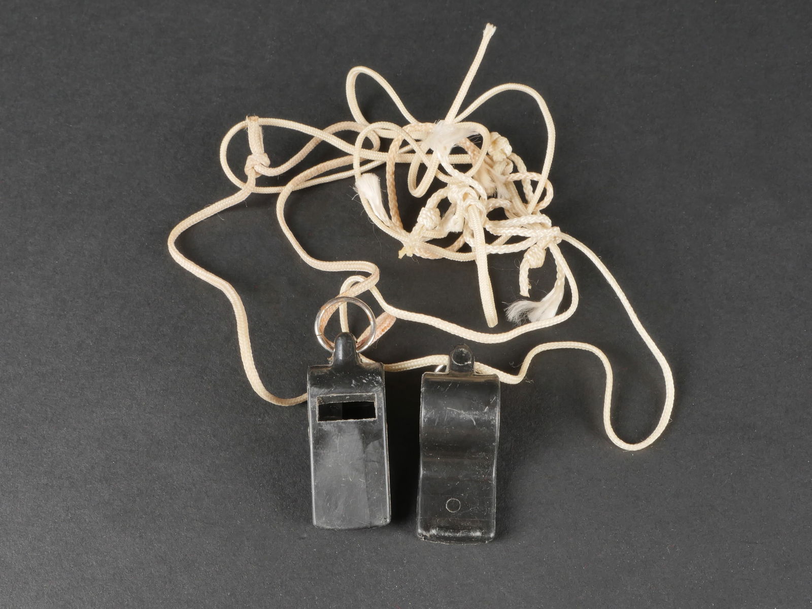 Siffletallemand. German Wistle.: Siffletsallemand. Deux sifflets en bakelite noir. Fonctionnels. Les cordons sont posterieurs. Sans marquages visibles.a noter une certaine usure et patine des pieces. Etat II+. German whistles. Two bl