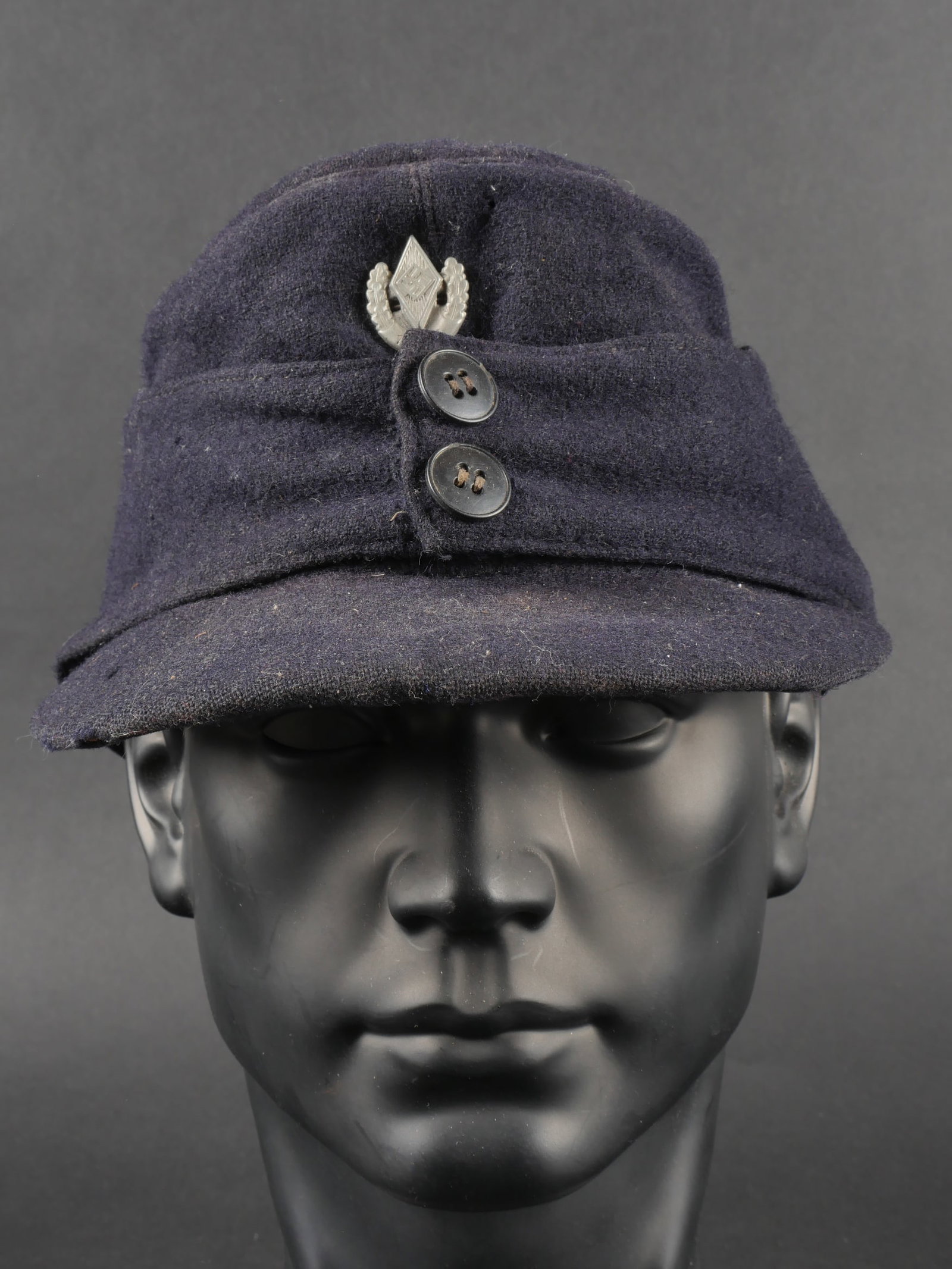 Casquette DJ. German Youth cap.: Casquette Deutsche Jungvolk. En drap bleu marine. Deux boutons fermant les rabats. Doublure de la visiere presentant des dechiruresau touche. Insignes Hitlerjugend 1943. Les insignes n ont pas ete dem