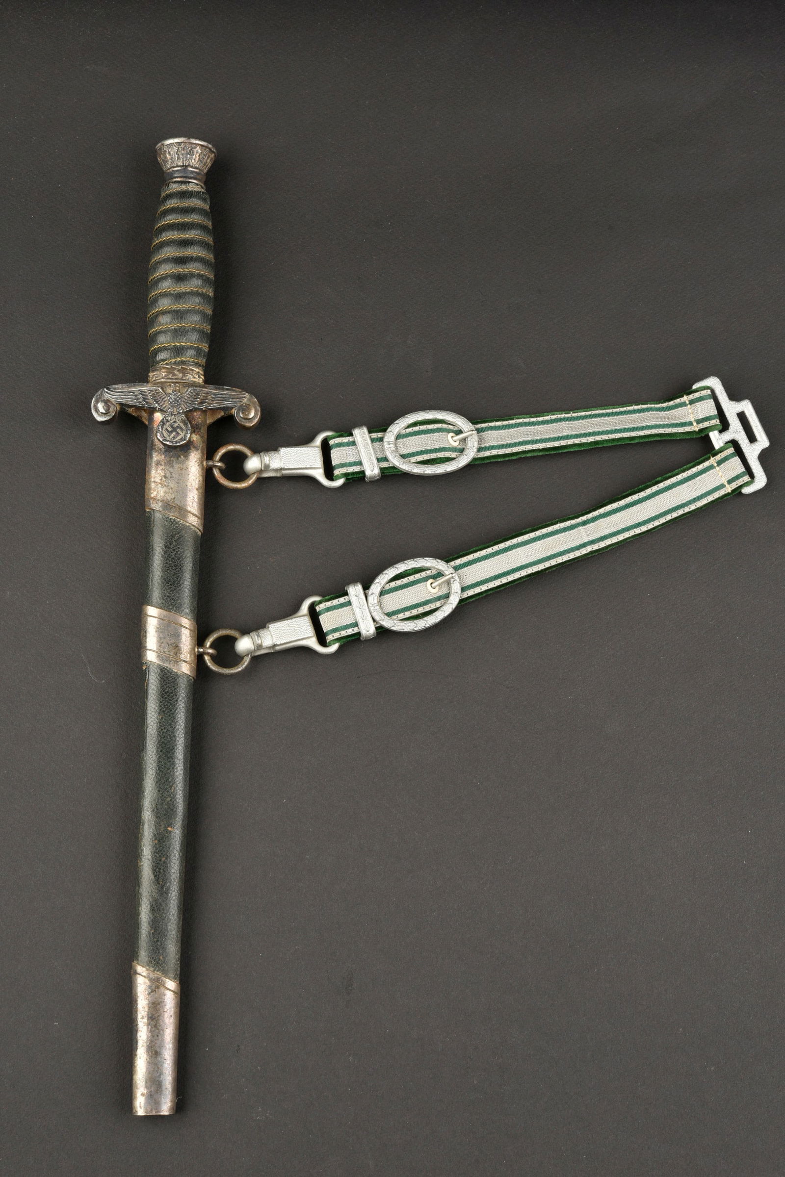 Dague Reichsfinanzverwaltung. German custom dagger.: Dague Reichsfinanzverwaltung. Garnitures metalliques noircies par l oxydation. Poignee recouverte de cuir vert, filigrane complet. Leger jeu entre la poignee et la garde. Garde disposant d unaigle de