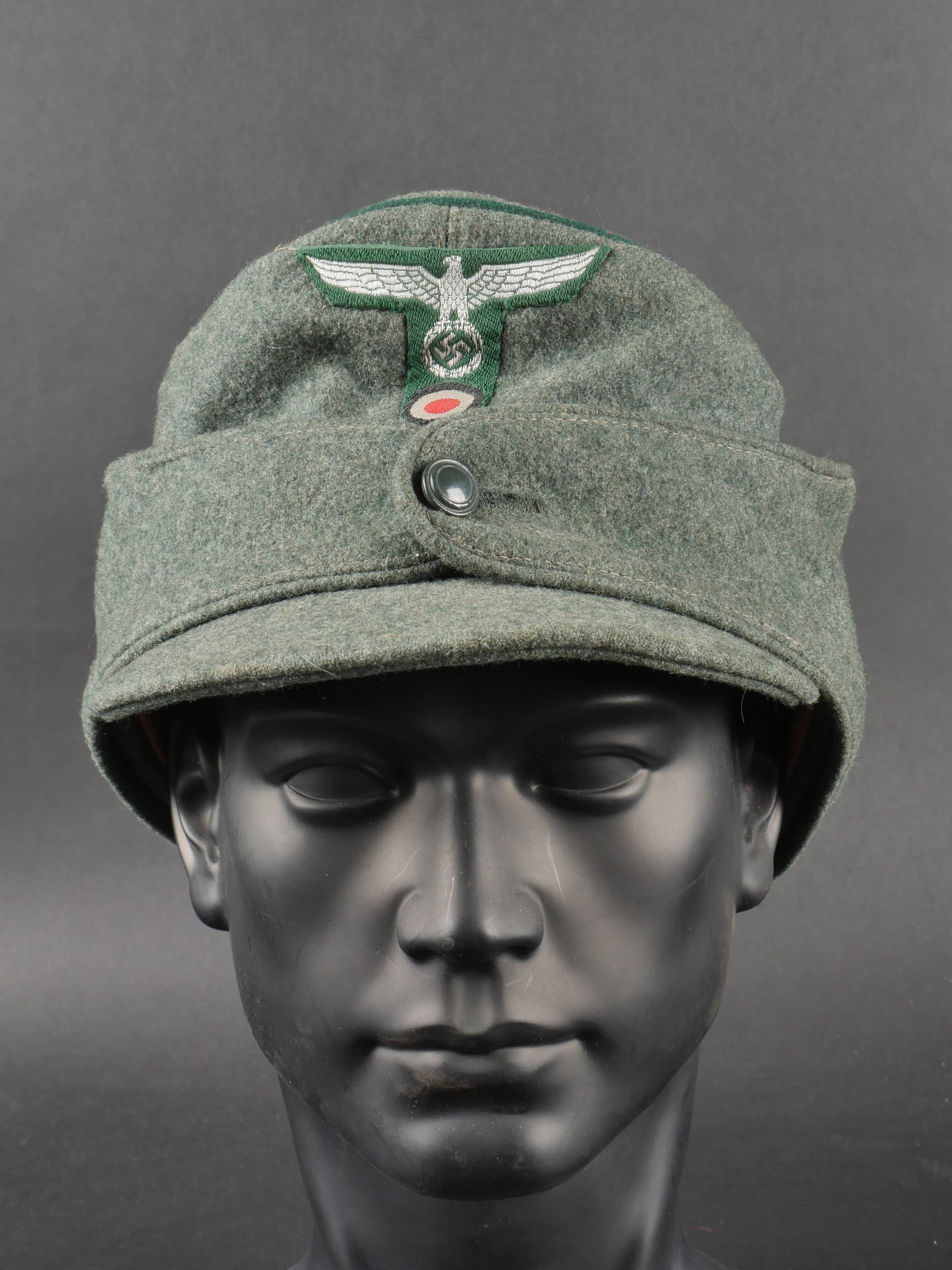 Casquette des douanes. German custom cap.: Casquette des douanes. En drap Feldgrau. Lisere vert fonce faisant le tour de la coiffure. Insignes tisses visiblement montes de maniere reglementaire. Edelweiss metallique sur le cote de la coiffure.