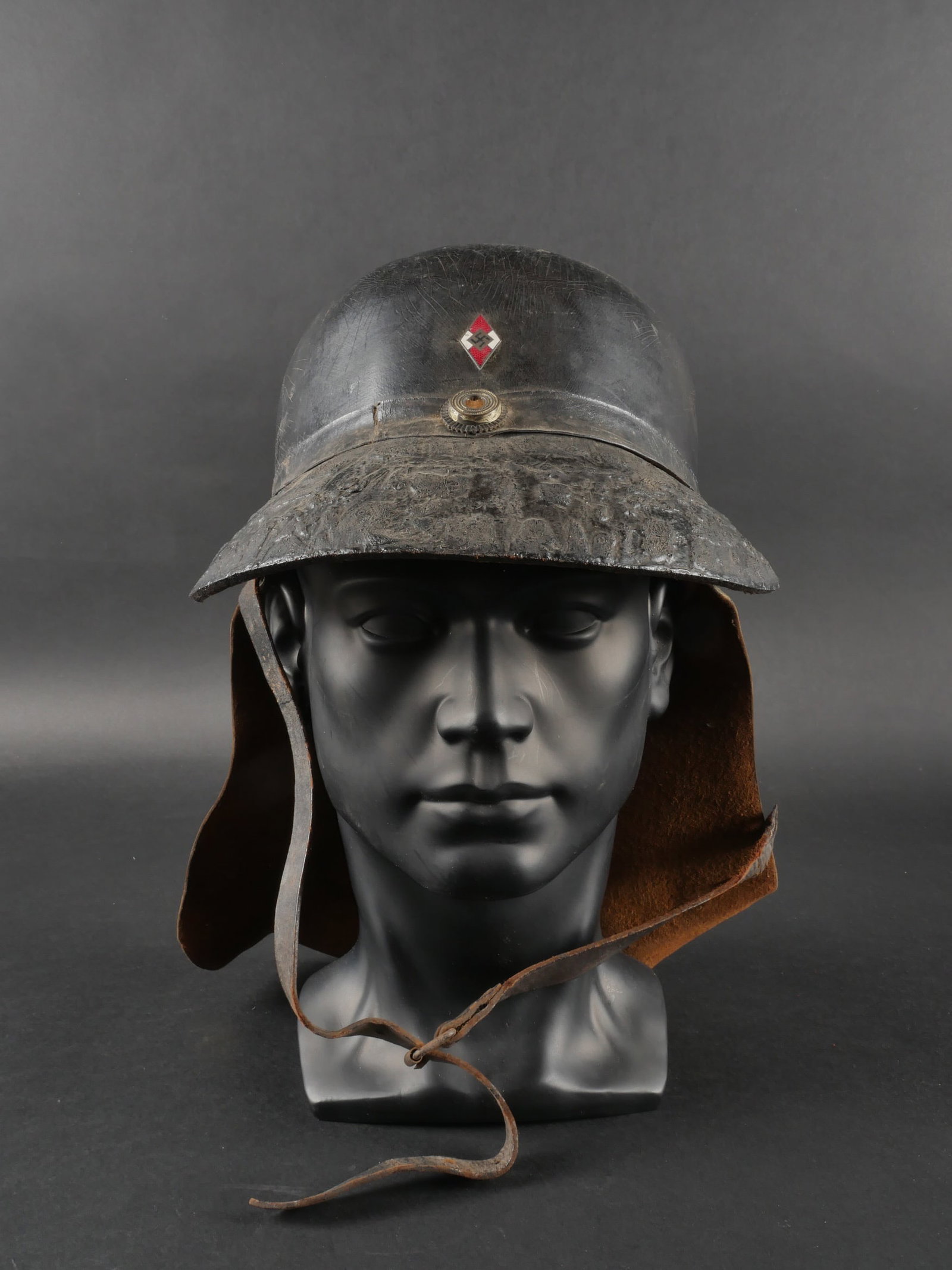 Casque de pompier HJ. Hitlerjugend firefighter helmet.: Casque de pompier Hitlerjugend. En fibre. Visiere fortement gonflee etabimee. Insignes metalliques. Les insignes n ont pas ete demontesafin de verifier lesattaches. Nuquiere complete. Jugulaire presen