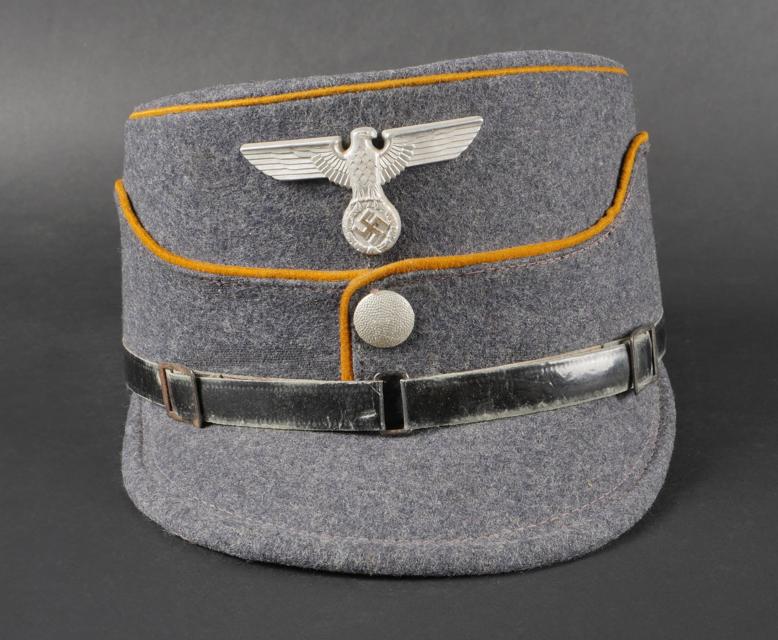 Kepi NSFK. NSFK cap.: Kepi NSFK. En drap gris/bleu. Double lisere jaune faisant le tour de la coiffure. Bouton greneleargent.aigle metallique. L insigne n a pas ete demonteafin de verifier lesattaches. Fausse jugulaire en 