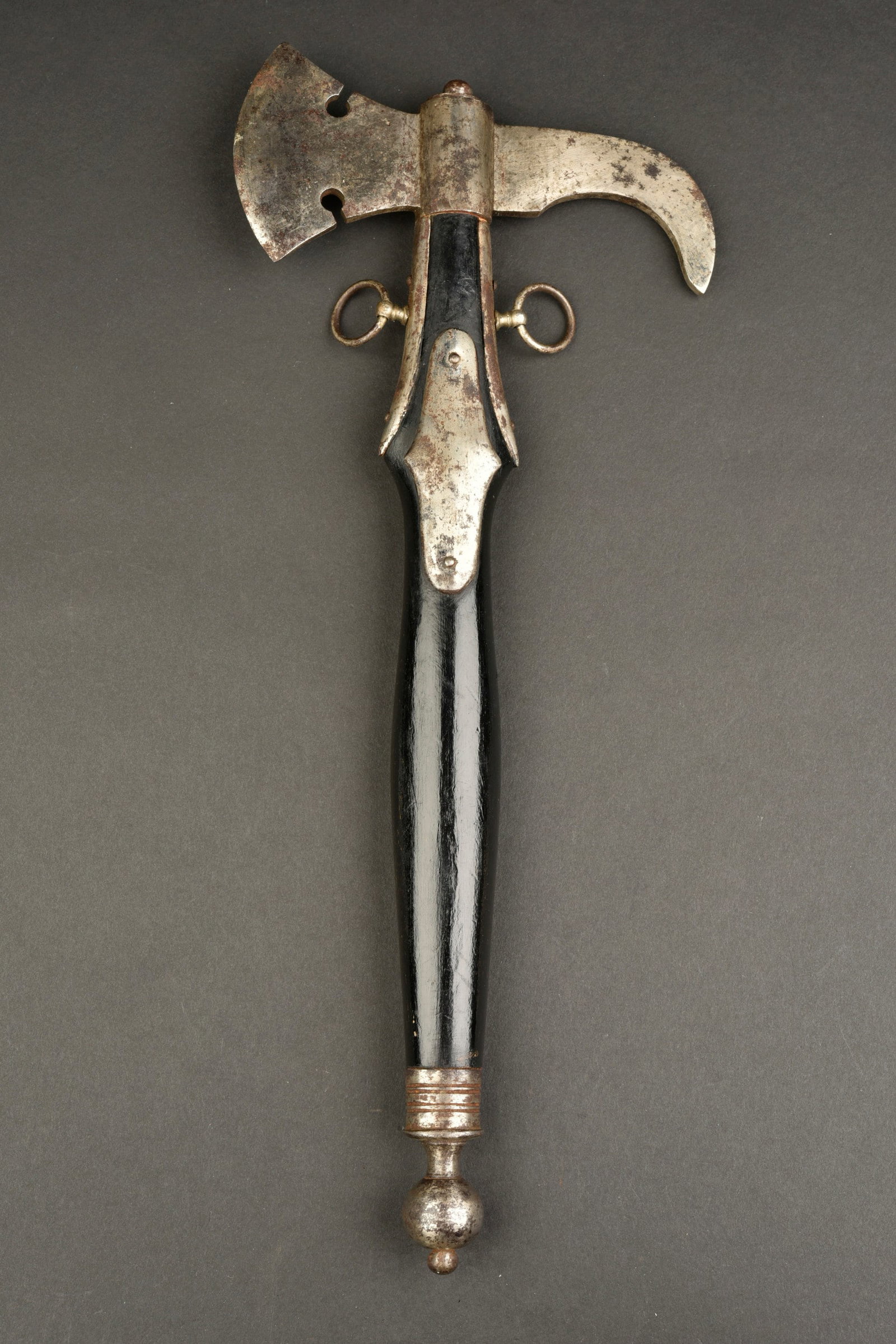Hache de pompier. German firefighteraxe.: Hache de pompier. Manche en bois noir. Garnitures en metal nickele. Useavec des manques. Lesanneaux de suspensions sont presents. Sans marquages visibles.a noter une certaine usure et patine de la pie