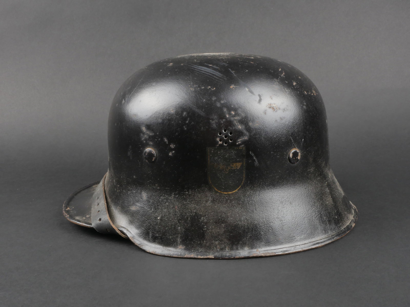Casque de la Reichsbahn. German Reichsbahn helmet.: Casque de la Reichsbahn. Coque de casque en metal. Peinture noire visiblement posterieure. Insignes nationaux a 85%. Insigne de la Reichbahn partiellement recouvert d un voile de peinture noire. Coiff