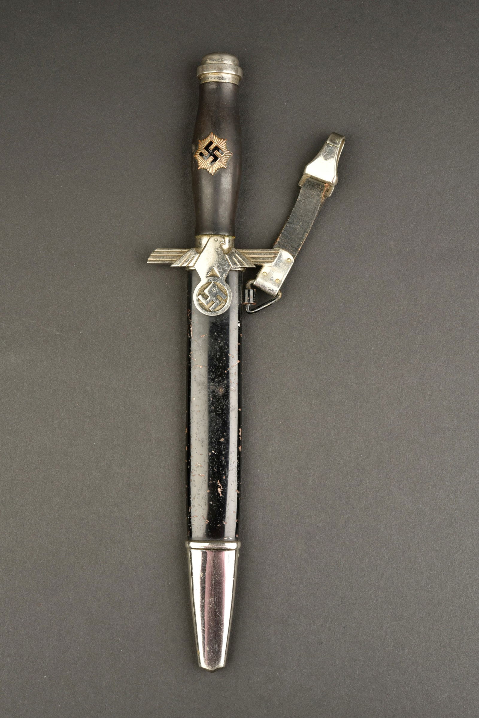 Dague du RLB. German RLB dagger.: Dague du RLB. Garnitures en metal. Poignee en bois noir. Insigne du RLB visiblement fixe d origine sur la poignee. Garde disposant d unaigle stylise. Fourreau en metal complet, couleur noire a 60%. La