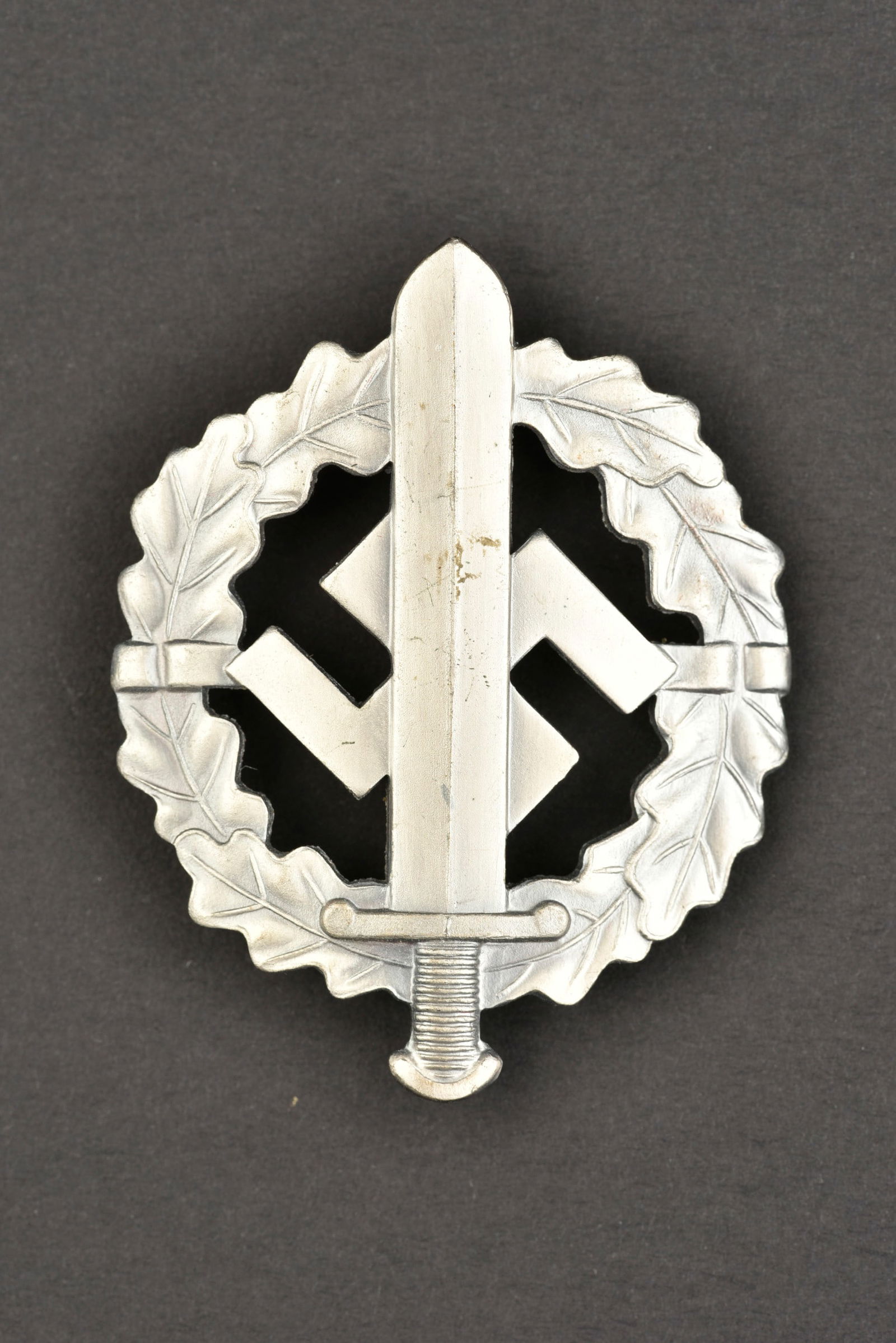 Insigne des sports SA. SA sport insignia.: Insigne des sports SA. En metal, couleurargent. Marquages W Redo Saar Lauter.attache complete.a noter une certaine usure et patine de la piece. Etat II+. SA sports badge. Metal, silver colour. Marking