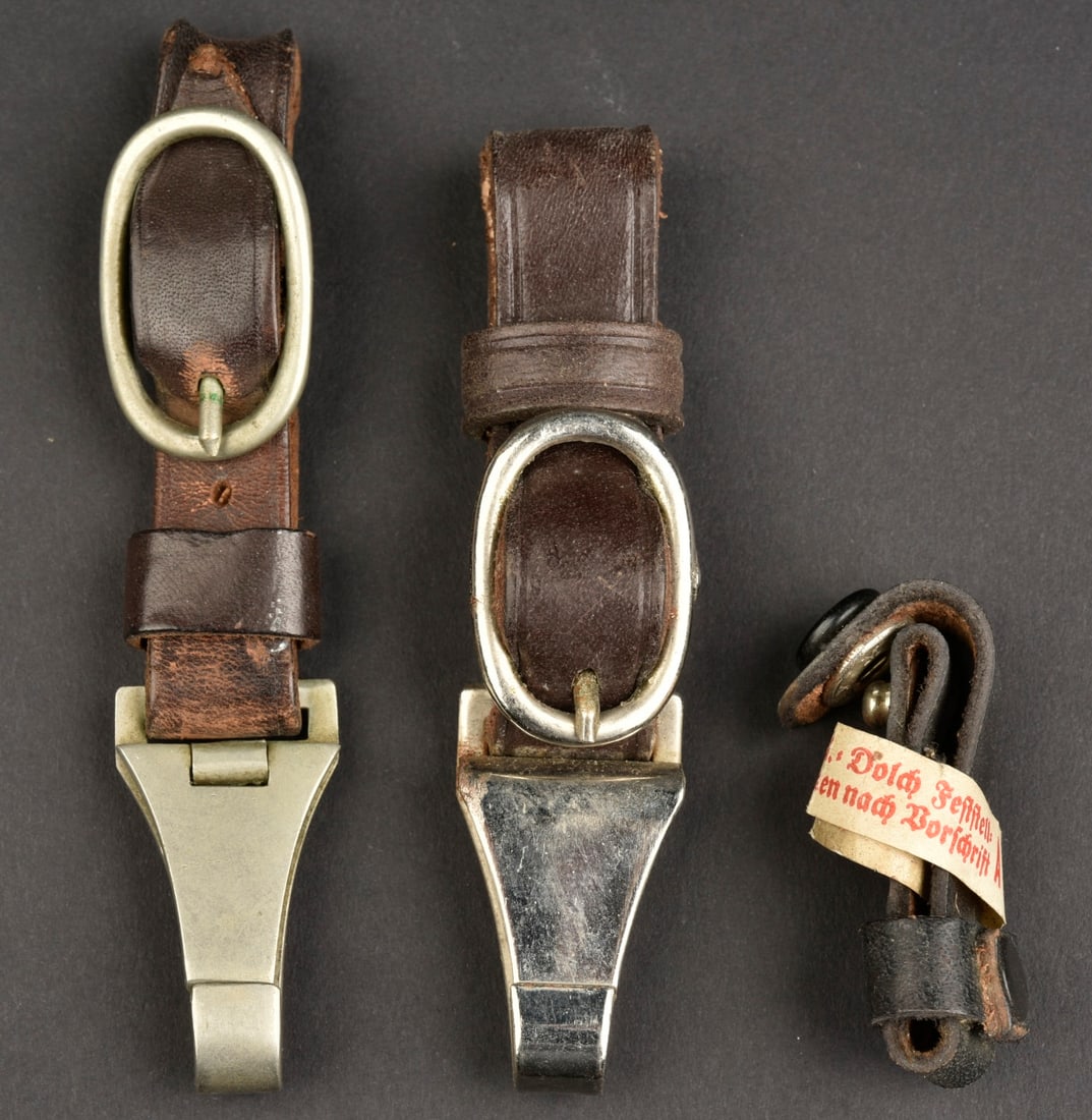 Belieres de dague SA. SA dagger straps.: Belieres de dague SA. Trois modeles de belieres en cuir. Une beliere est marquee RZM L2/371/39 RZM M5/25. Une beliere dispose d une etiquette RZM tres fragile.a noter une certaine usure et patine de l