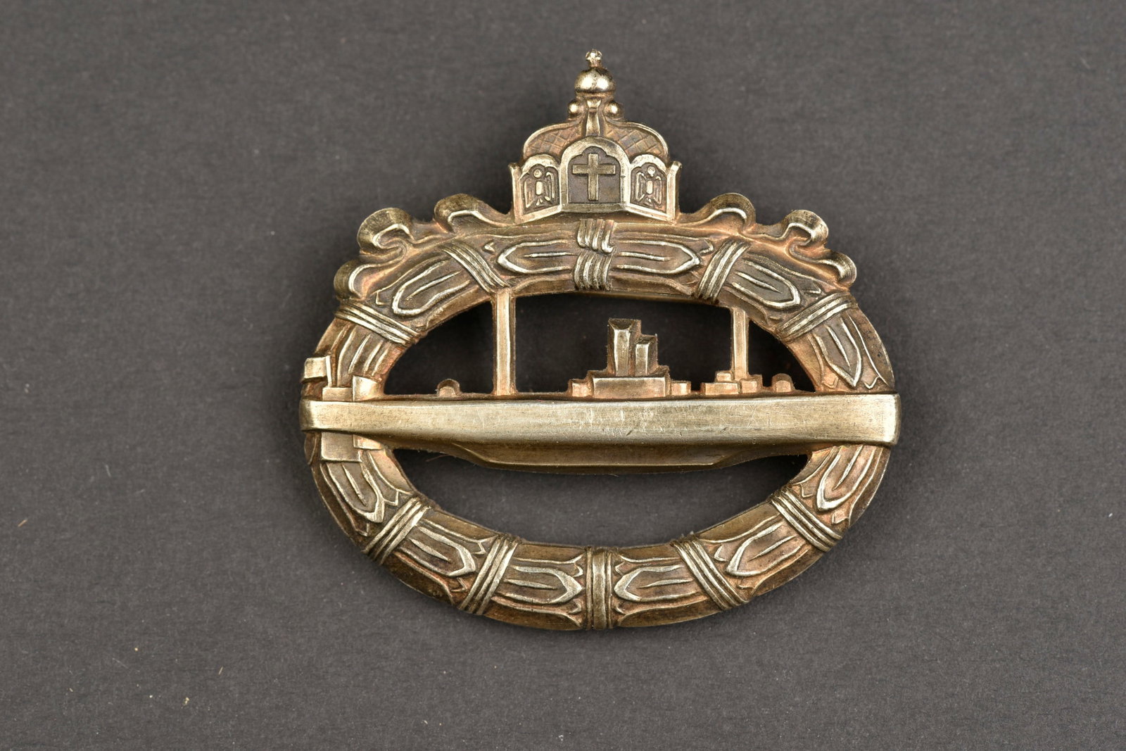 Brevet de sous-marinier WWI. WWI submariner s certificate.: Brevet de sous-marinier allemand WWI. En metal couleur argent, modele tres epais. Attache horizontale complete. Fabrication Walter Schot Fec. A noter une certaine usure et patine de la piece. Etat II+