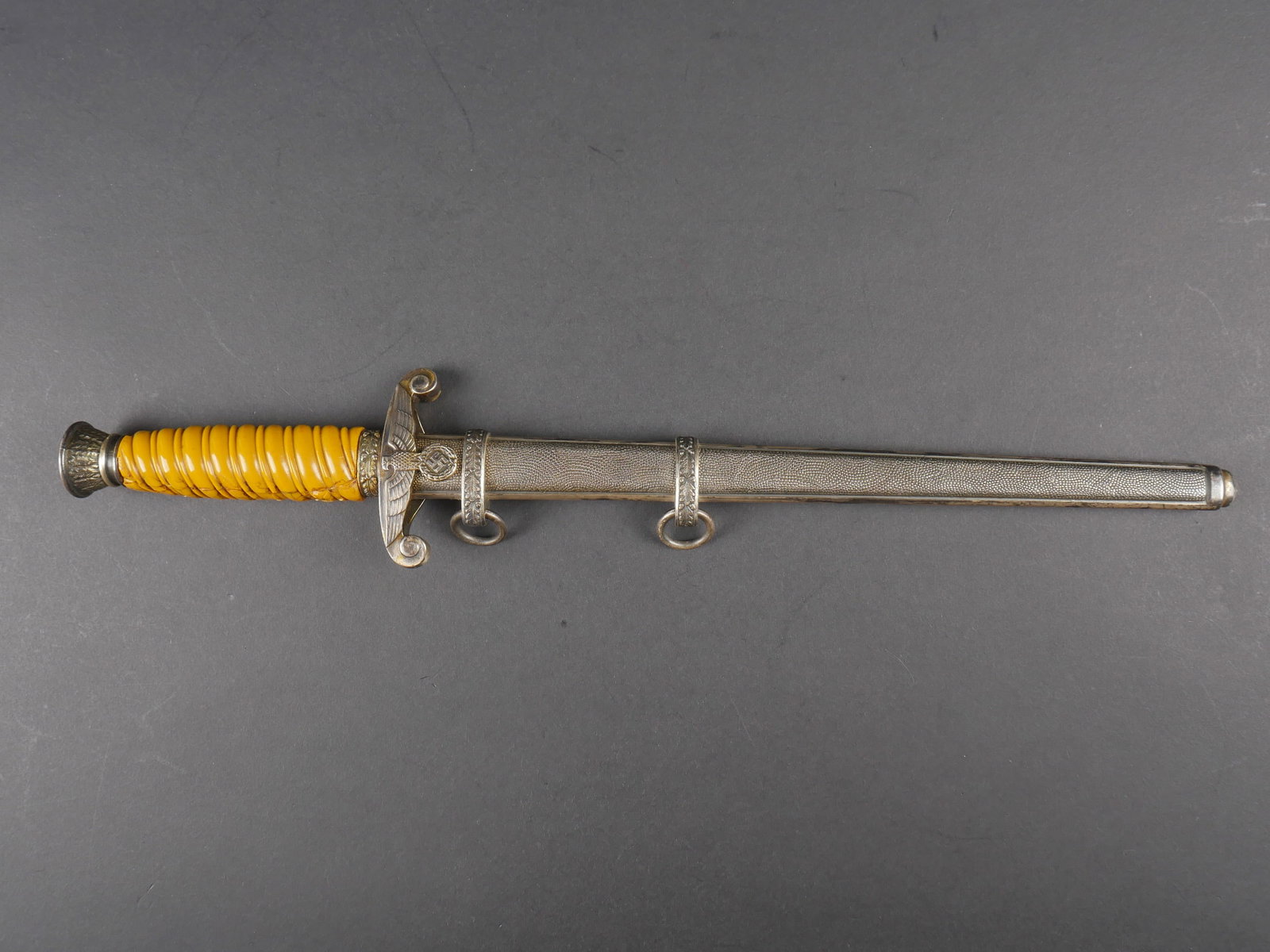 Dague officier Heer. Heer officer dagger.: Dague d officier de la Heer. Garnitures en metal. Poignee jaune fortement abimee et recollee. Bel aigle allemand au niveau de la garde. Lame presentant des marques d usure et d oxydation. Fabrication 