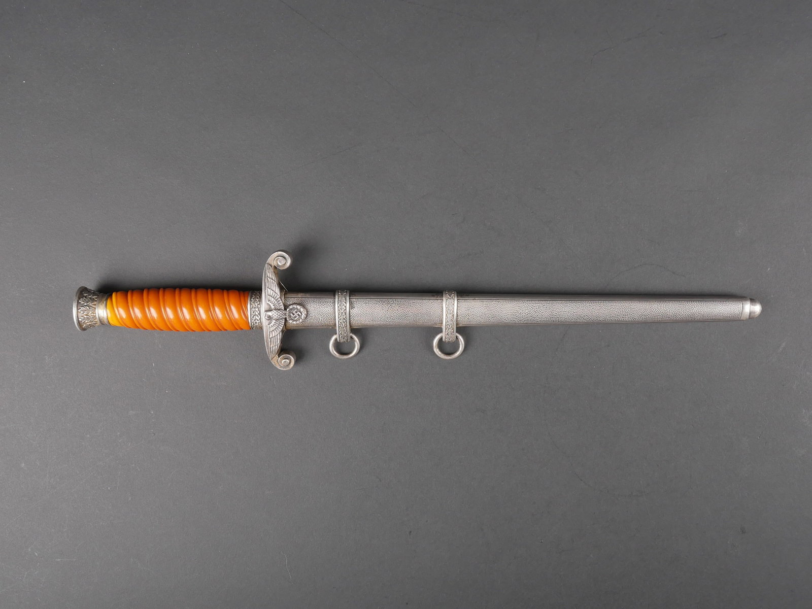 Dague officier Heer. Heer officer dagger.: Dague d officier de la Heer. Garnitures en metal. Poignee en celluloid orange. Bel aigle allemand au niveau de la garde. Lame presentant des marques d usure et d oxydation. Fabrication Eickhorn Soling