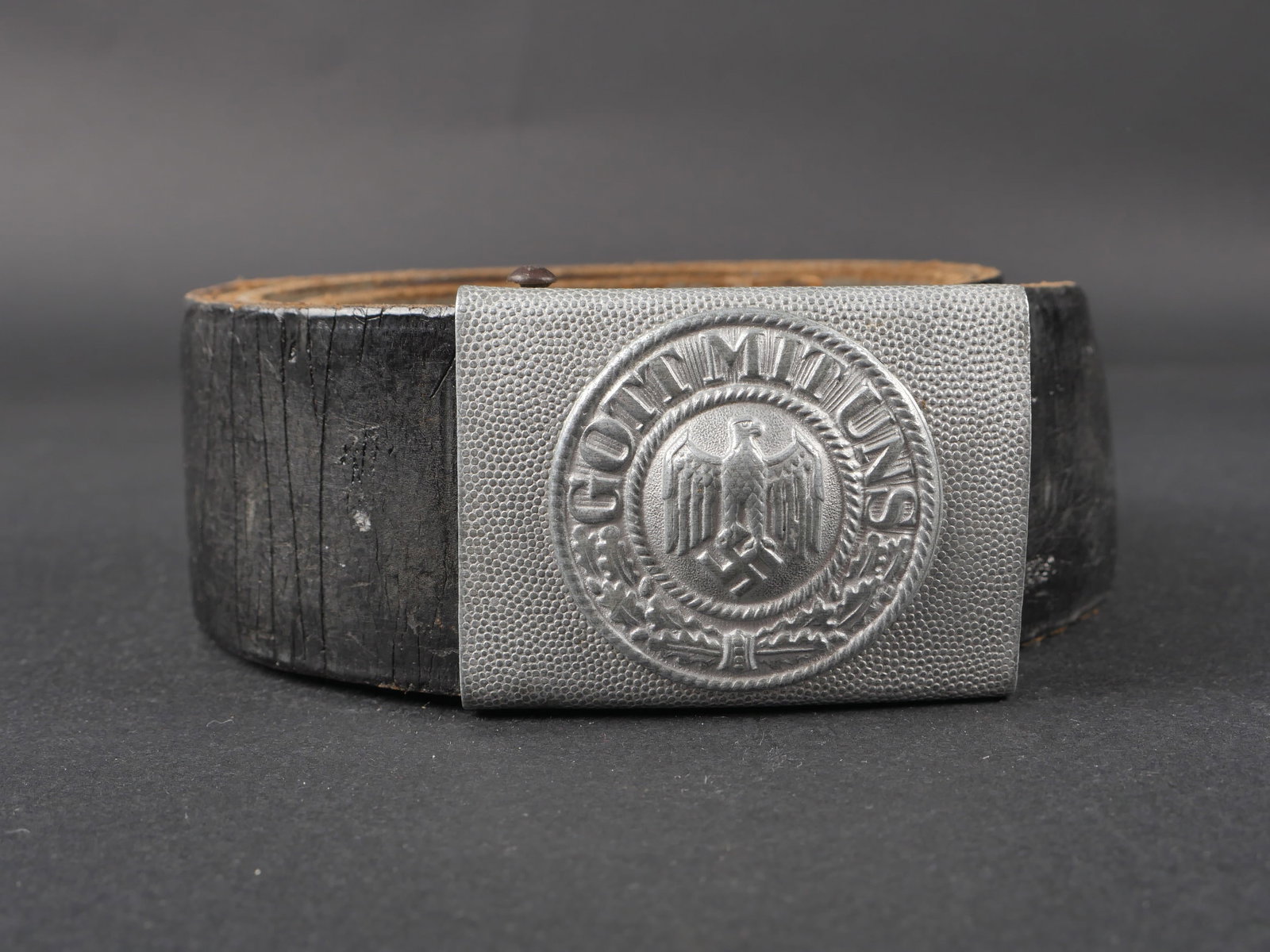 Ceinturon de la Heer. German belt: Ceinturon de la Heer. En cuir noir, bouclerie en metal. Doublure en drap gris, fortement use et mite. Patte de reglage en cuir. Sans marquages visibles. Boucle de ceinturon en aluminium grenele, bosse
