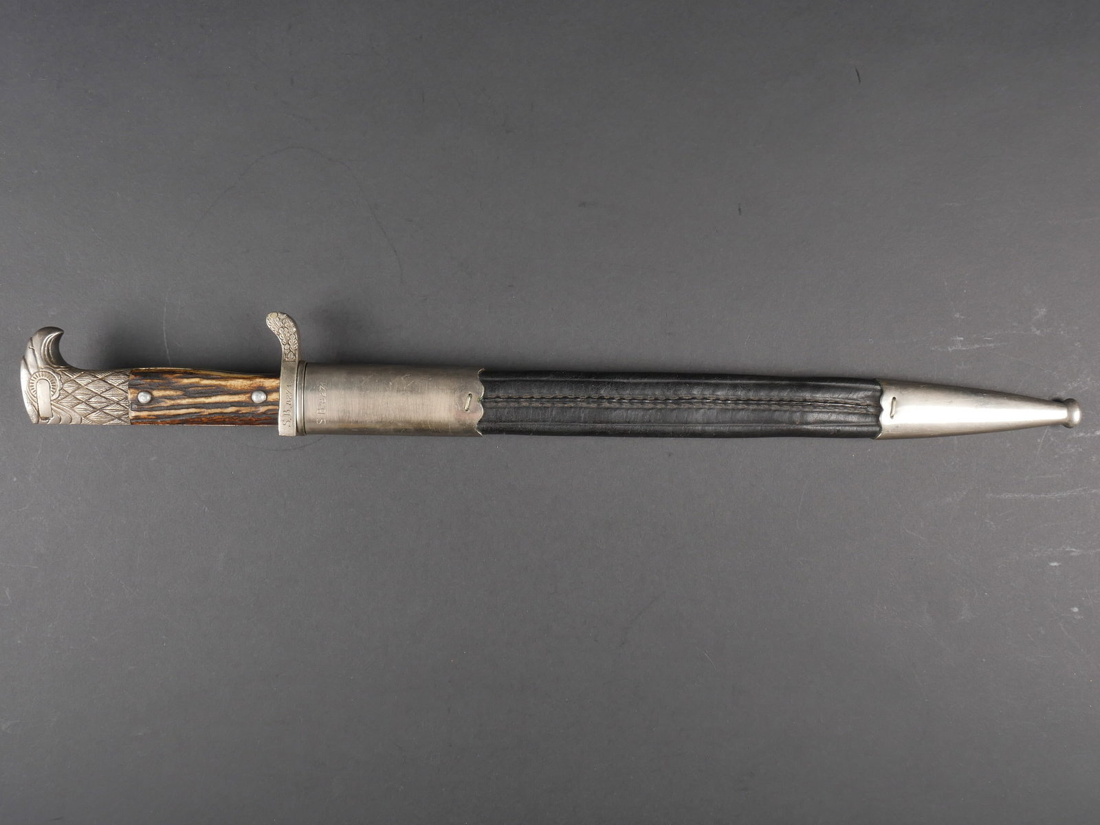 Baionnette Polizei. Polizei bayonet.: Baionnette Polizei. Pommeau a tete d aigle, bouton poussoir fonctionnel. Manches en imitation corne. Insigne Polizei en metal, visiblement monte d origine sur une plaquette. Garde a decors de feuilles