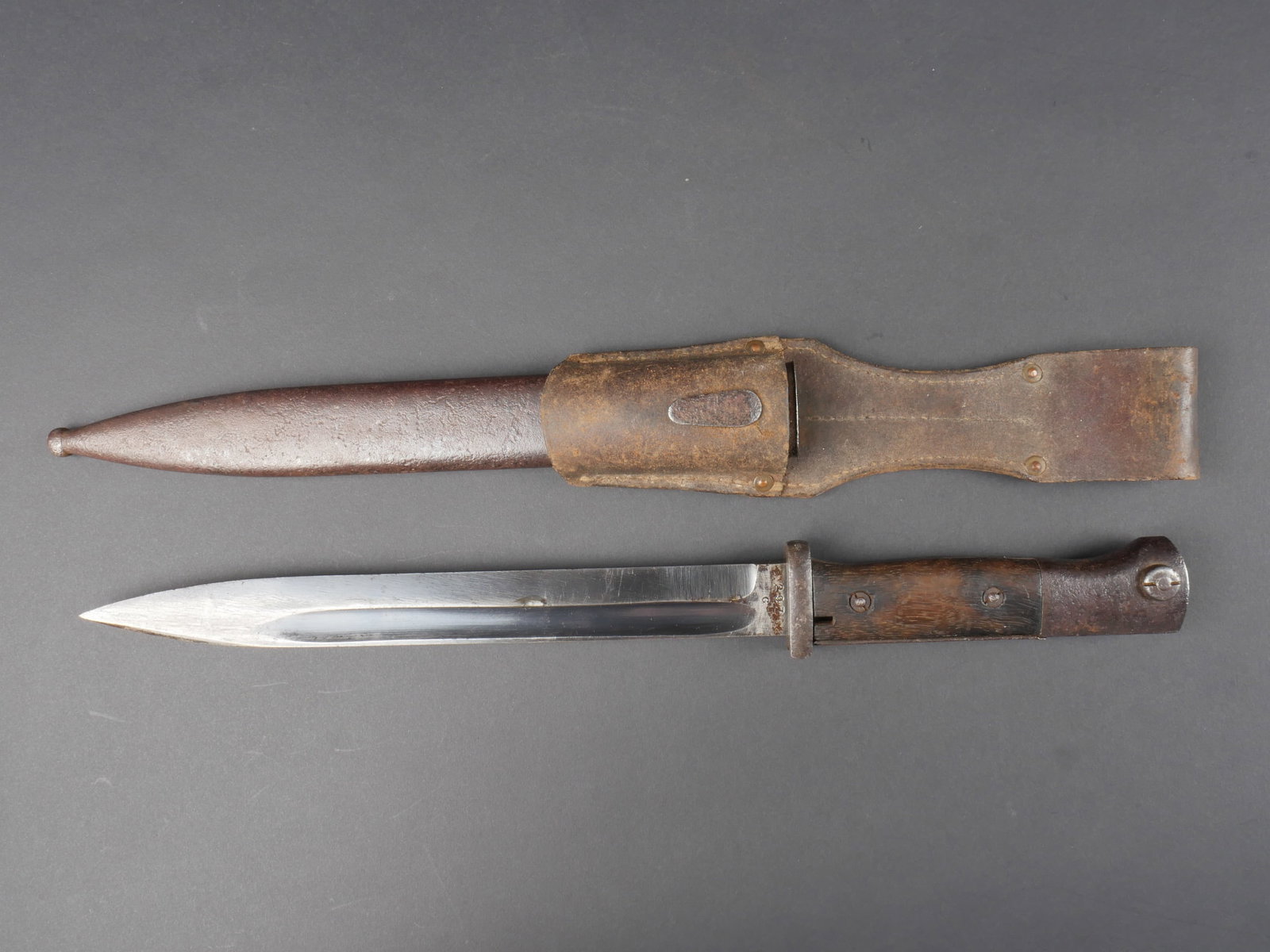 Baionnette de Mauser 98K. Mauser 98K bayonet.: Baionnette de Mauser 98K. Garnitures en metal oxyde. Plaquettes en bois. Lame dans sa couleur d origine a 60%. Marquages 43 FNJ, numero 297C. Fourreau en metal fortement oxyde, fabrication FNJ 43, num