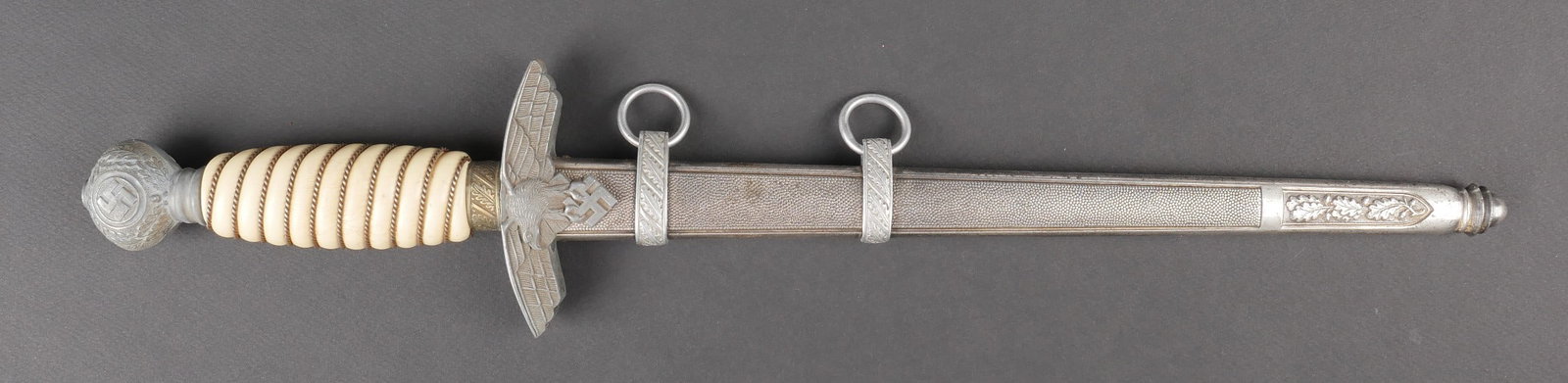 Dague officier LW. Luftwaffe officer dagger.: Dague d officier de la Luftwaffe. Garnitures en metal. Les dorures des insignes nationaux sont manquantes. Poignee en celluloid blanche, nombreuses fissures visibles. Filigrane present. Garde disposan