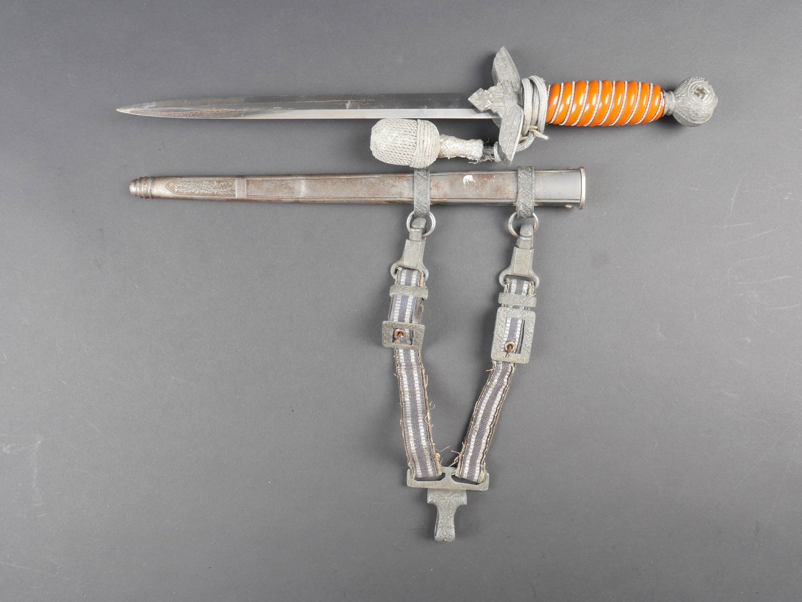Dague officier LW. Luftwaffe officer dagger.: Dague d officier de la Luftwaffe. Garnitures en metal. Les dorures des insignes nationaux sont manquantes. Poignee en celluloid orange fonce, quelques fissures visibles. Filigrane present. Garde dispo