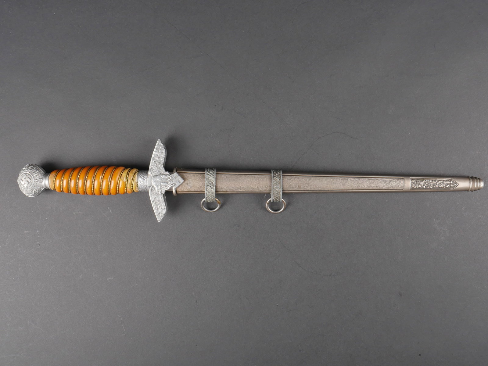 Dague officier LW. Luftwaffe officer dagger.: Dague d officier de la Luftwaffe. Garnitures en aluminium. Les dorures des insignes nationaux sont manquantes. Poignee en celluloid jaune, quelques fissures visibles, ainsi que des reparations. Filigr
