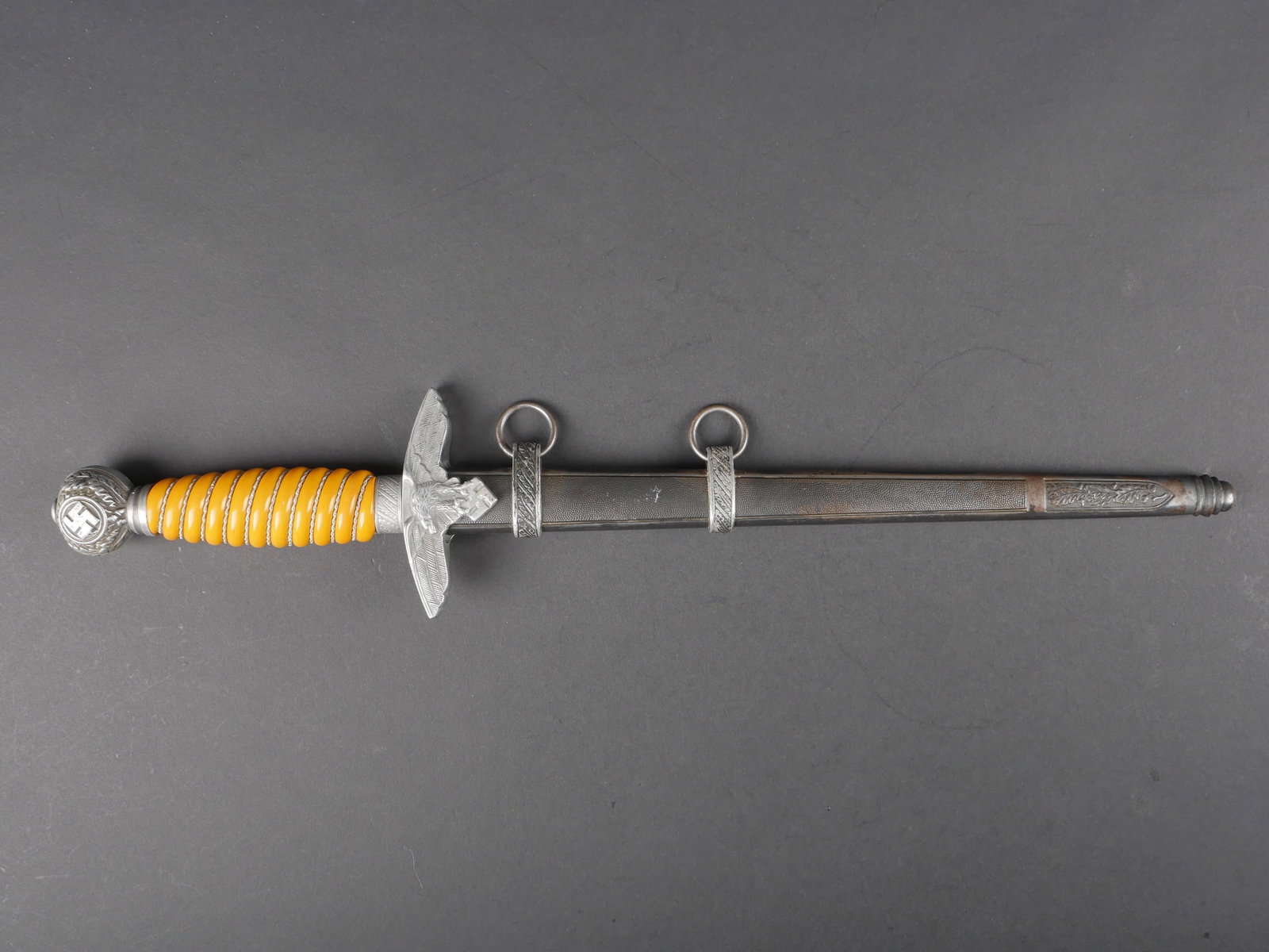 Dague officier LW. Luftwaffe officer dagger.: Dague d officier de la Luftwaffe. Garnitures en metal. Les dorures des insignes nationaux sont manquantes. Poignee en celluloid jaune. Filigrane present. Garde disposant d un aigle finement cisele. Be