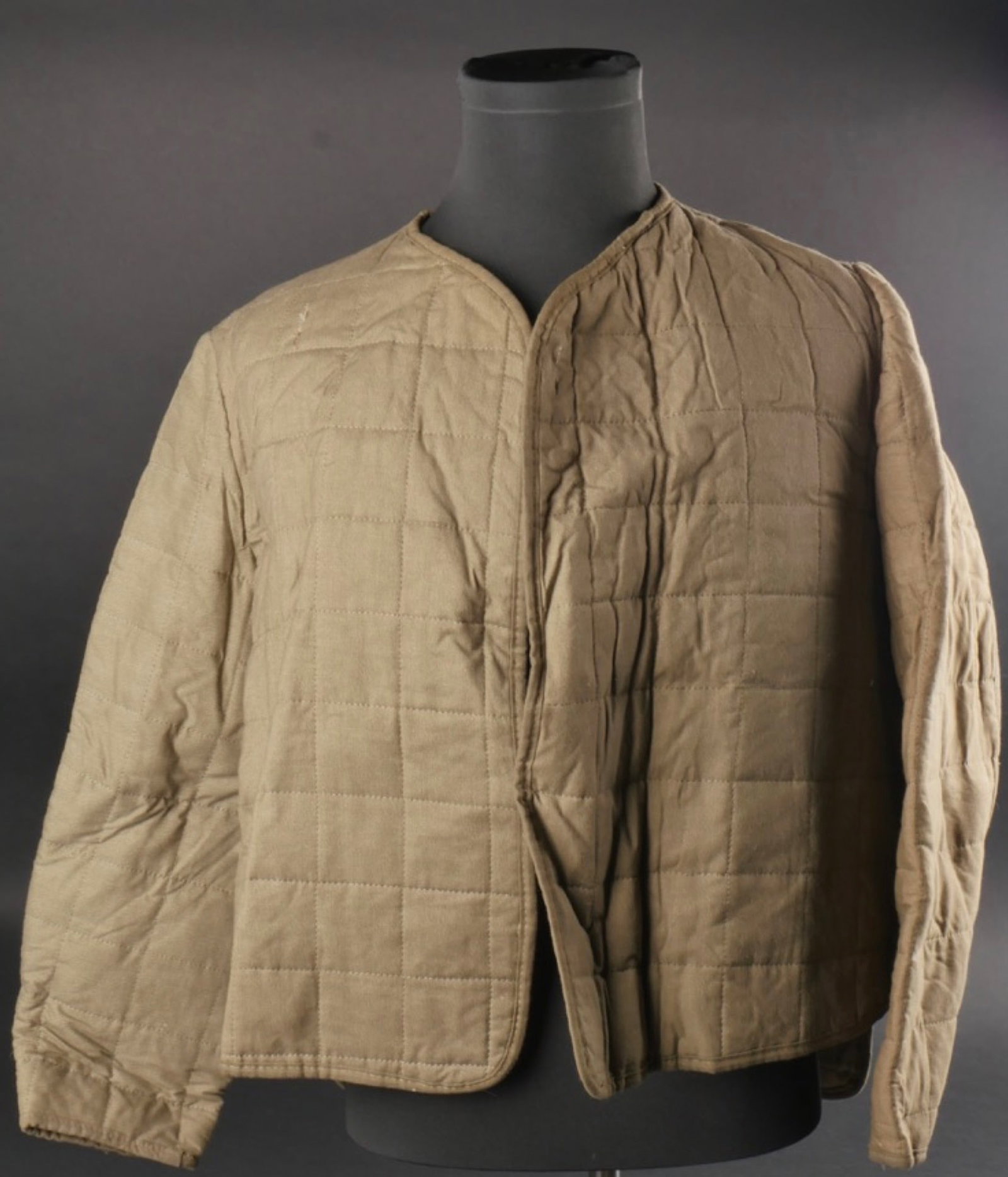 Sous veste matelasse. Under padded jacket.: Sous veste matelassee. En toile grise matelasse. Manches longues. Aerations sous les aisselles. Sans systeme de fermeture. Marquages RBNr 0/0350/0445 GS&CO, taille 1. A noter une legere usure et patin