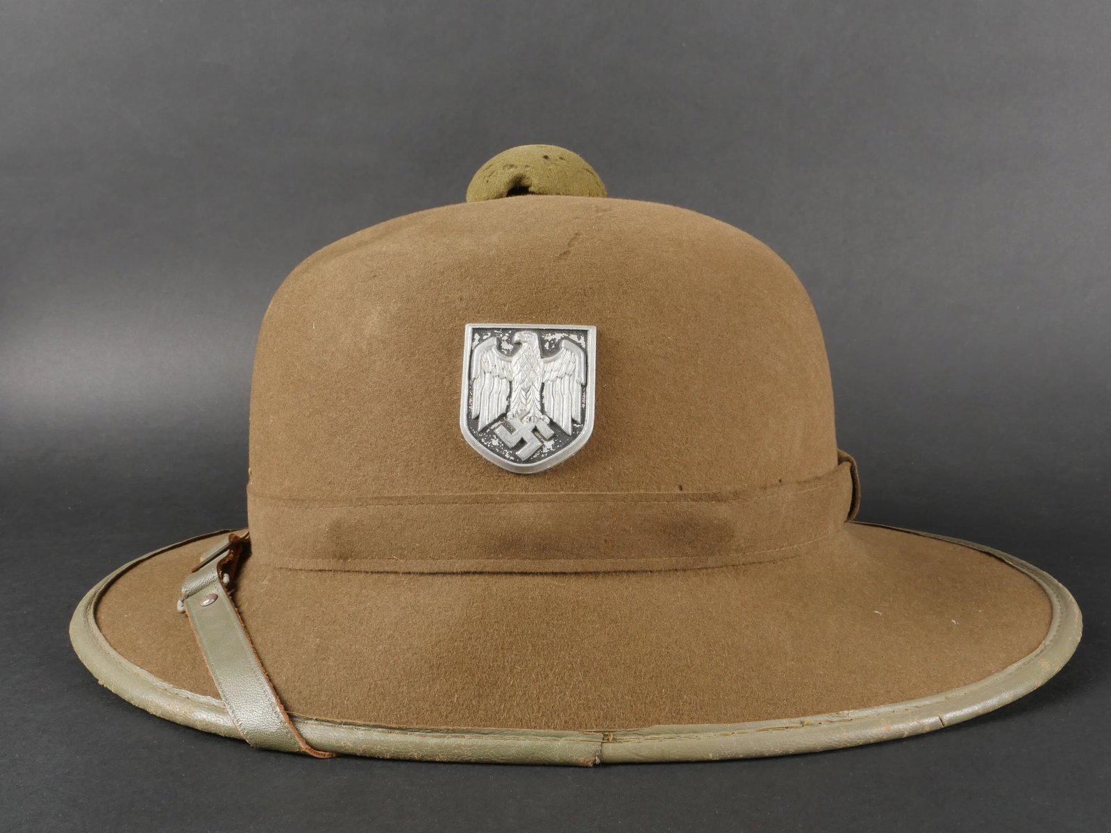Casque tropical Heer. German tropical helmet.: Casque tropical Heer. En feutrine kaki. Nombreux trous de mite sur l ensemble de la coiffure. Insigne en aluminium peint. Les insignes n ont pas ete demontes afin de verifier les attaches. Jugulaire e